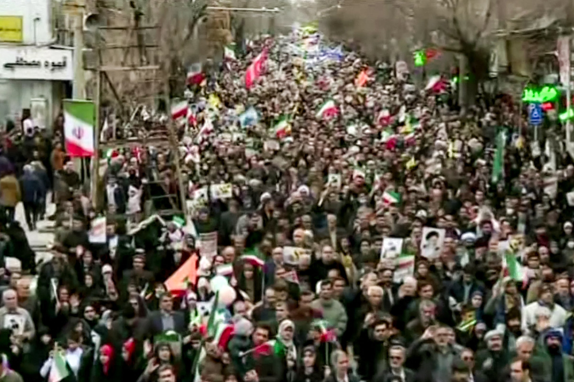 This grab taken from handout video footage released by Iran Press on February 11, 2026, shows people marching in Tehran to mark the 47th anniversary of the 1979 Islamic revolution.