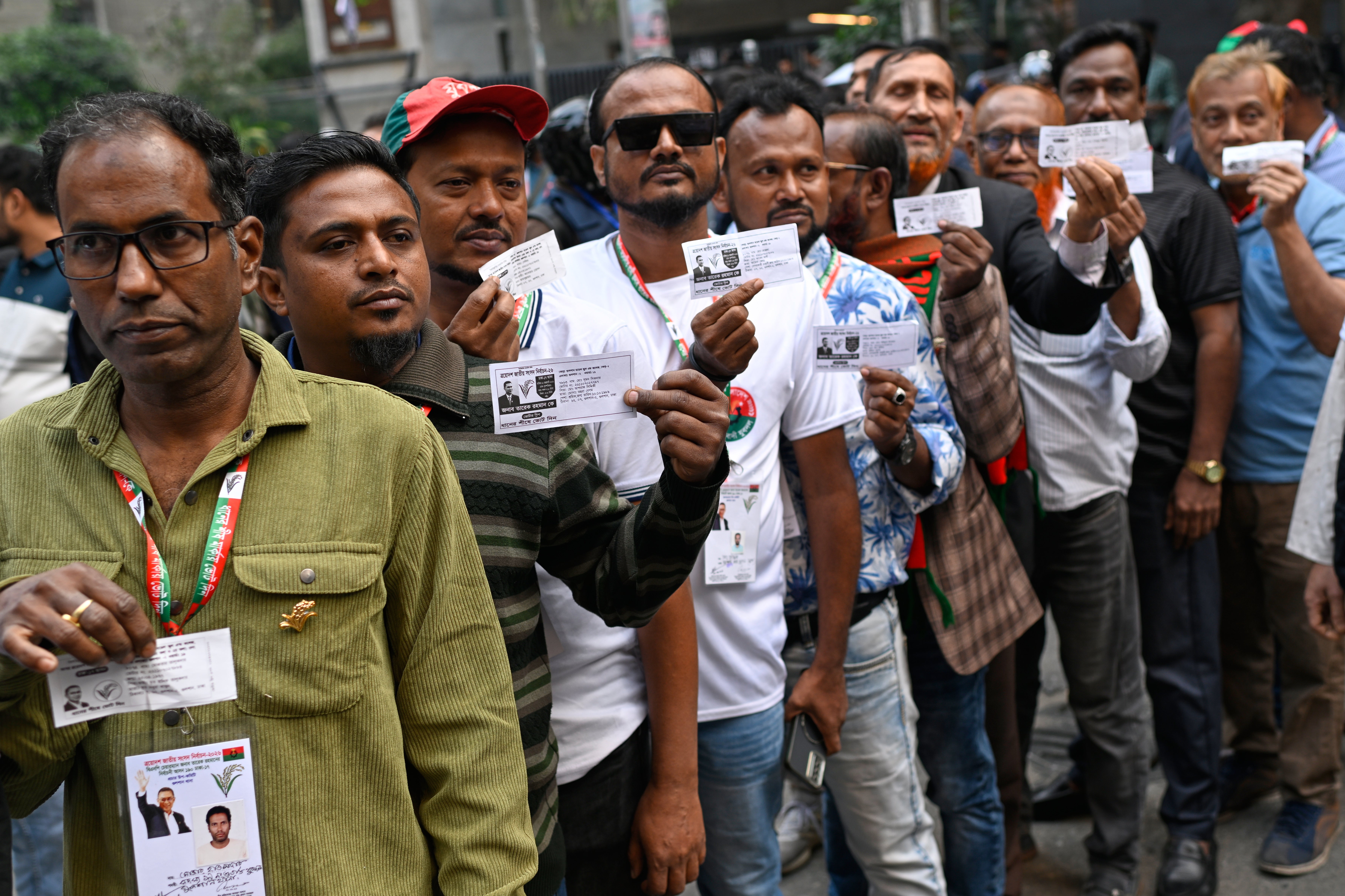 Voters wait in line outside a polling centre to cast their ballots during the national parliamentary elections in Dhaka, Bangladesh, Thursday 12 Feb