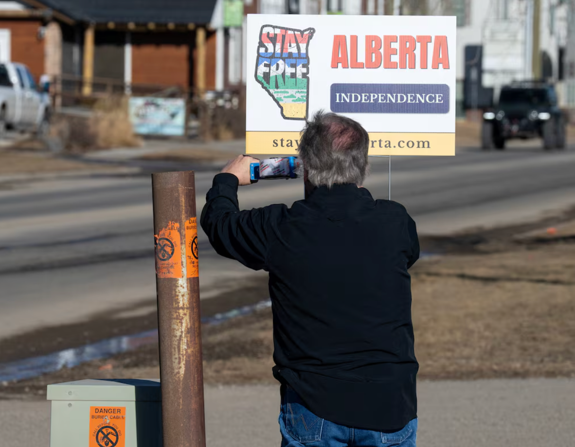 A volunteer with the Alberta Independence movement puts up a campaign sign at a petition signing location in High River, Alberta, earlier this month
