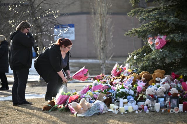 <p>A woman places flowers at a makeshift memorial for the victims two days after a deadly mass shooting took place at a school, in the town of Tumbler Ridge, British Columbia, Canada February 12, 2026</p>