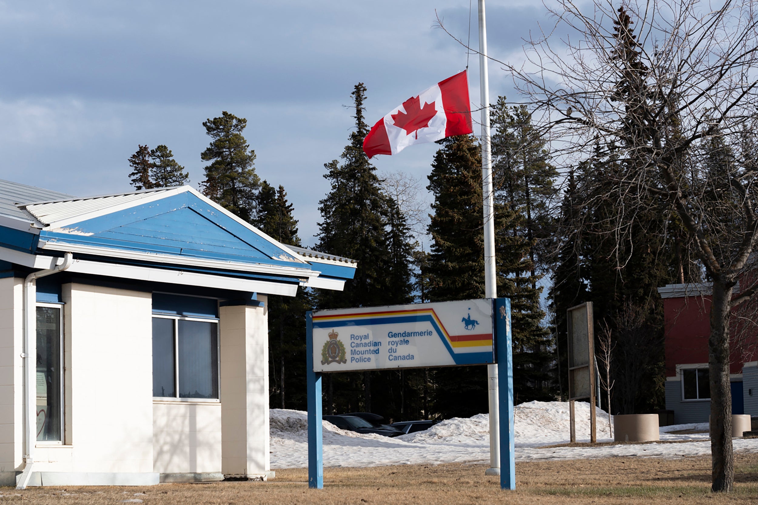 A Canadian flag flies at half mast at the Royal Canadian Mounted Police Station in Tumbler Ridge after Tuesday's mass shooting