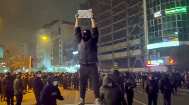 <p>In this image from video obtained by the AP outside Iran, a masked demonstrator holds a picture of Iran's Crown Prince Reza Pahlavi during a protest in Tehran, Iran, on Jan. 9, 2026</p>