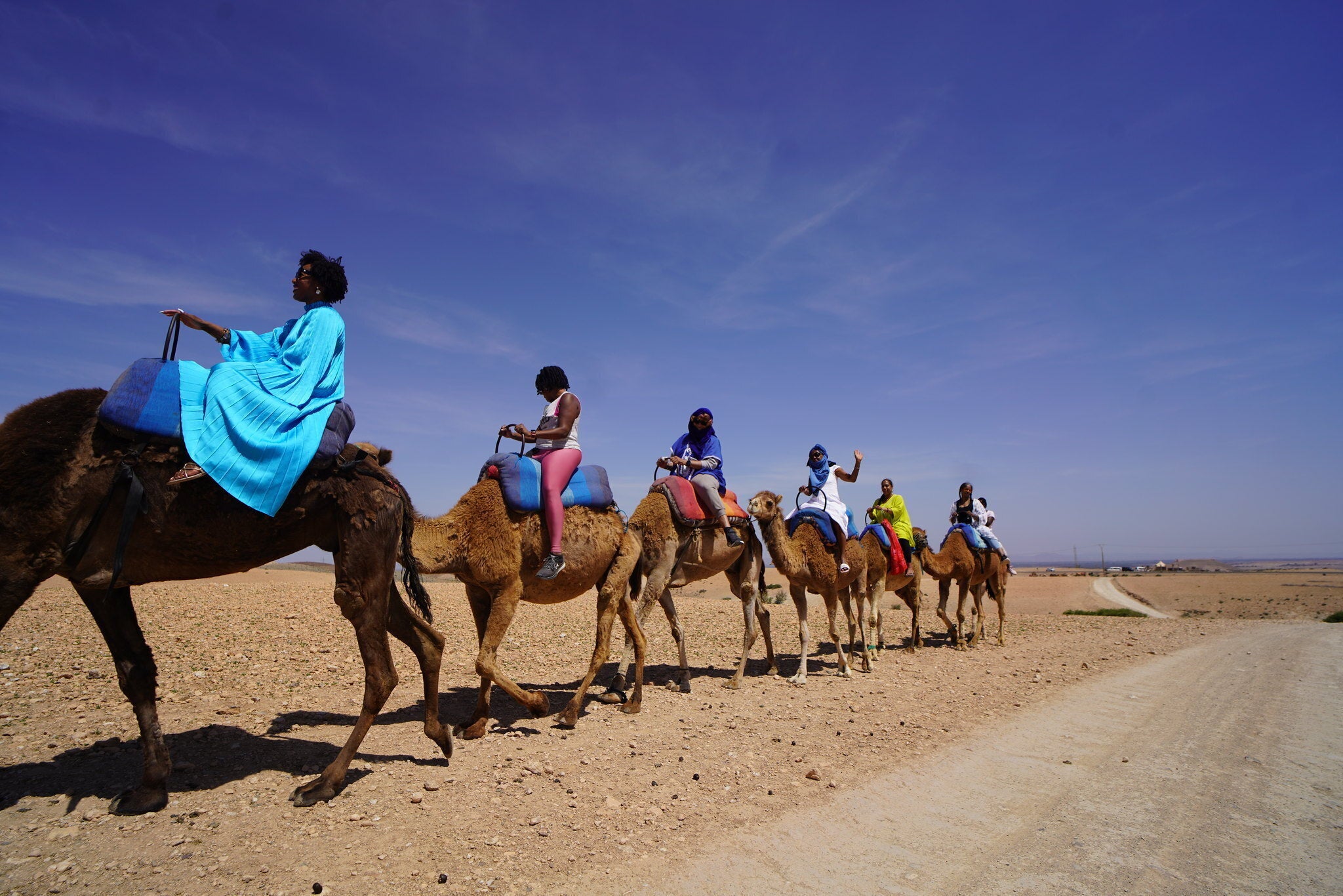 Roshida Dowe, foreground, rides a camel accompanied by several participants of the ExodUS Summit, an event business she co-leads to help Black women take career breaks and move abroad