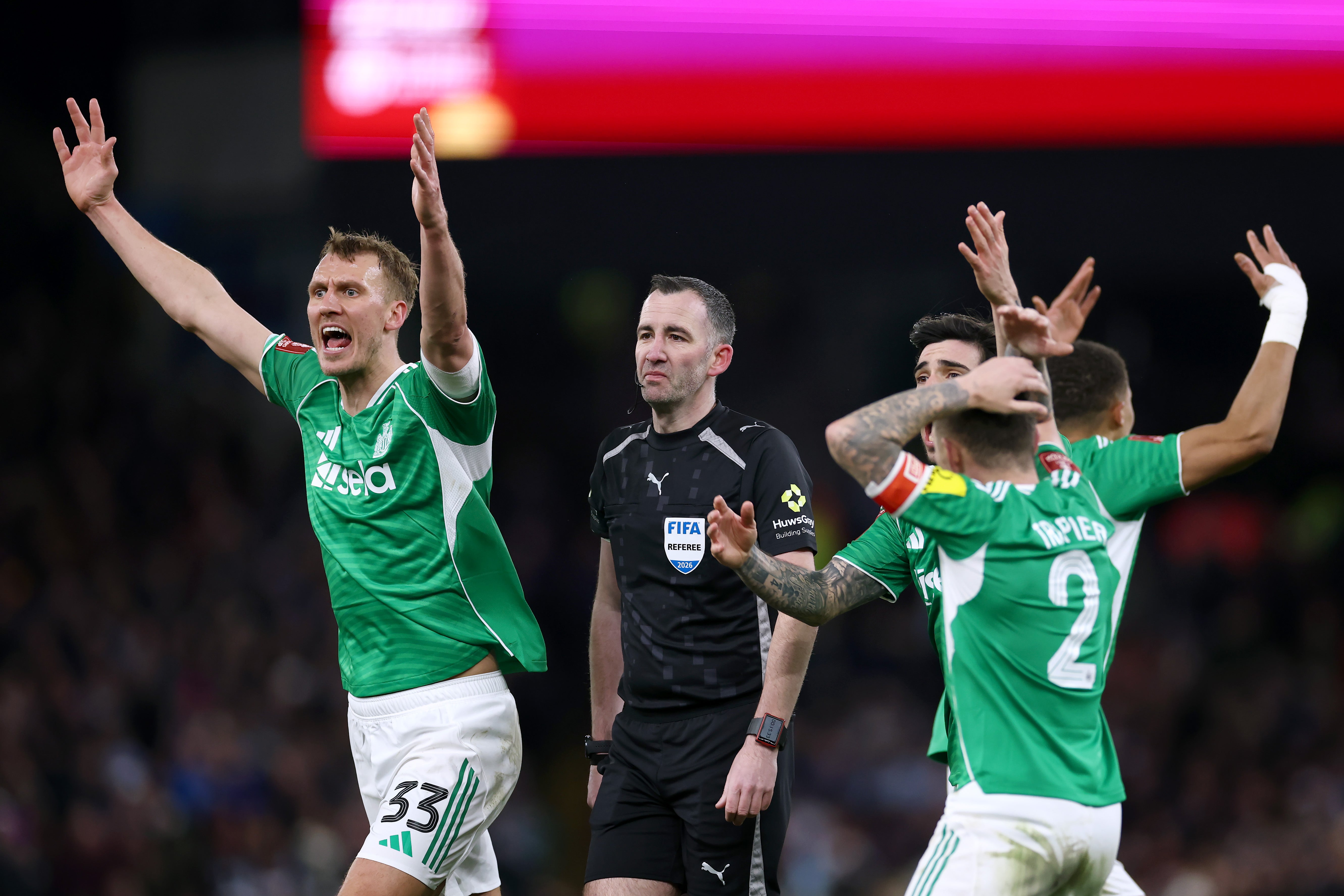 Kieran Trippier, Dan Burn and Sandro Tonali of Newcastle United react after referee Chris Kavanagh and assistant referee Nick Greenhalgh failed to award a penalty during the Emirates FA Cup Fourth Round match between Aston Villa and Newcastle United