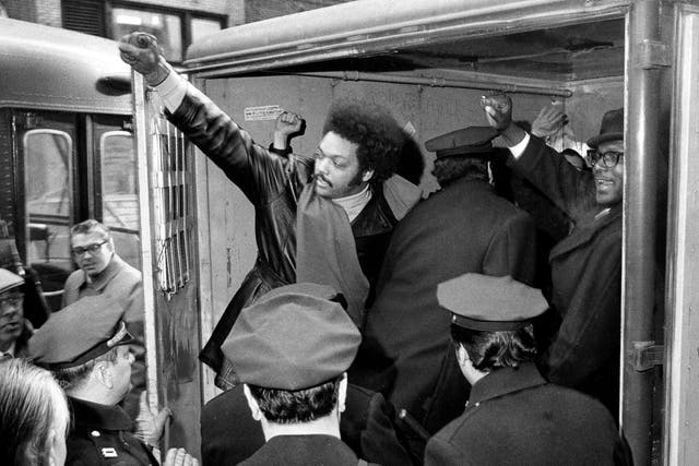 <p>Jesse Jackson raises a clenched fist from a police van after he and 11 others from Operation Breadbasket were arrested during a New York sit-in in 1971</p>