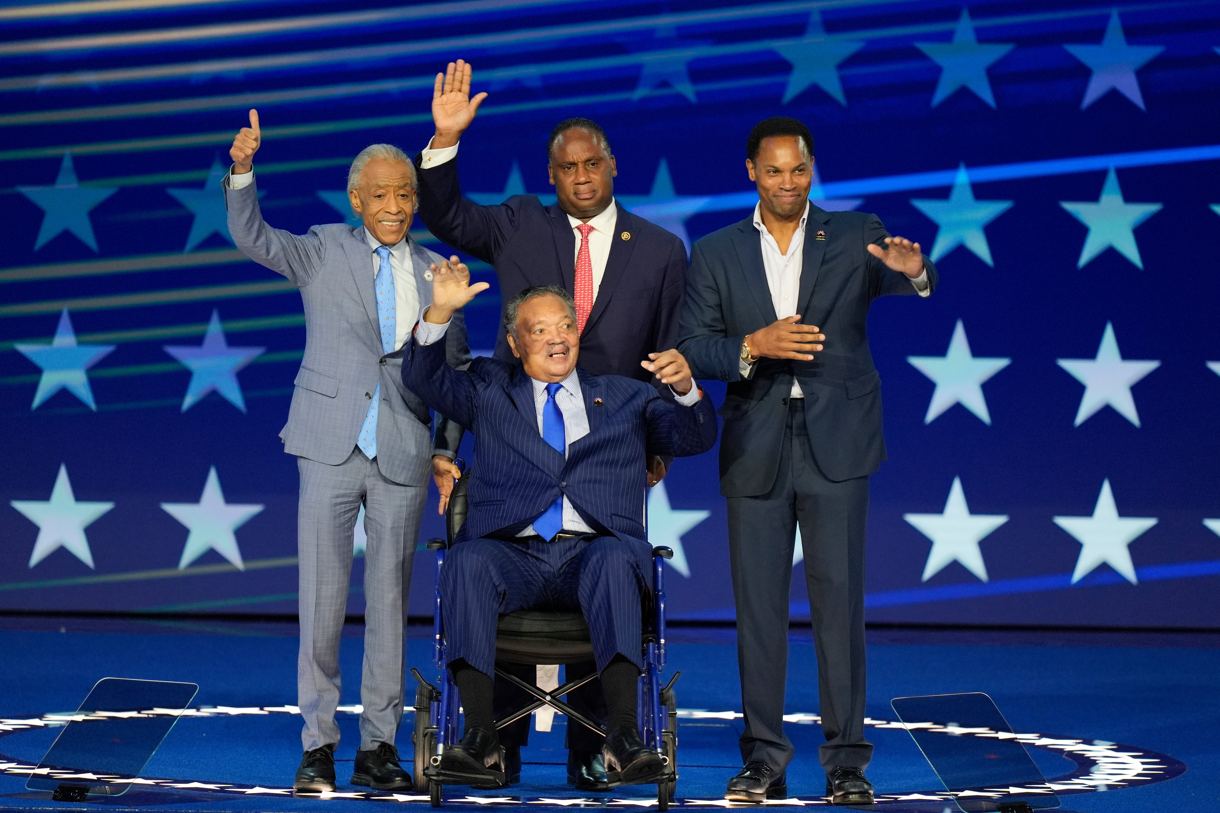 Rev. Jesse Jackson, center, waves to supporters as he is introduced during the Democratic National Convention with Al Sharpton, Jonathan Jackson and Yusef DuBois Jackson
