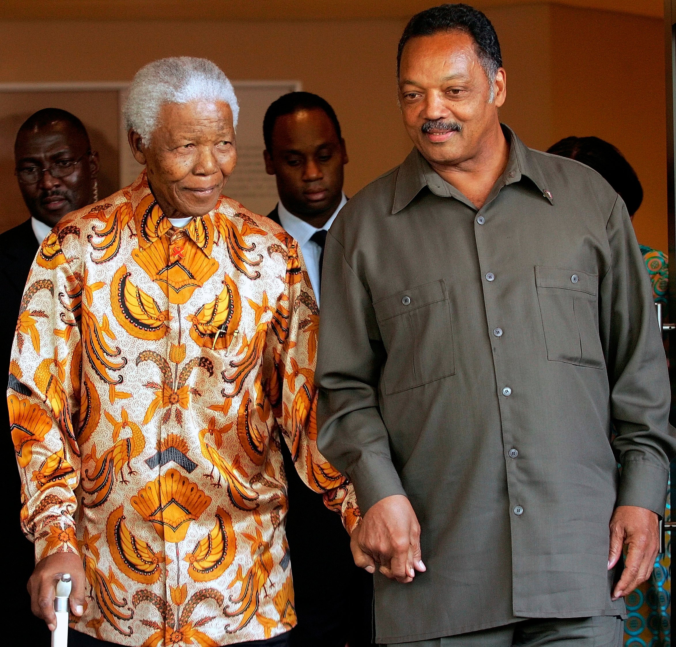 Former South African President Nelson Mandela, left, walks with the Rev. Jesse Jackson after their meeting in Johannesburg, South Africa