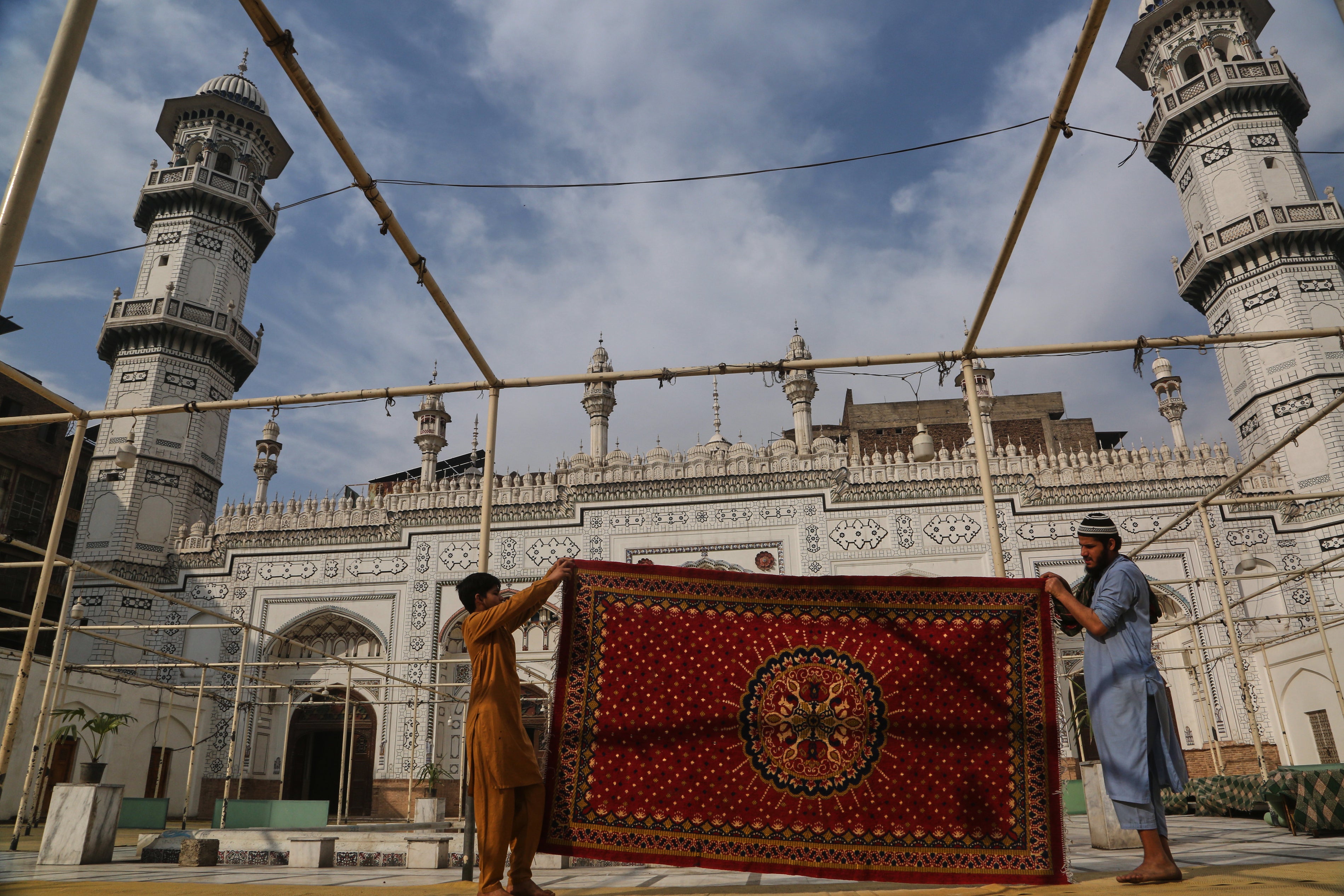 Workers clean carpet at the historic Mahabat Khan mosque in preparation for the upcoming Muslim fasting month of Ramadan, in Peshawar, Pakistan,