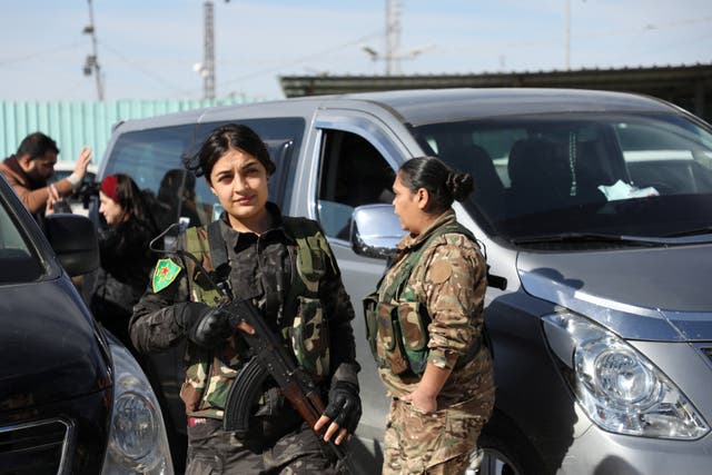 <p>Members of Women's Protection Units of the Syrian Democratic Forces stand near camp staff members, as Australian families believed to be linked to the Islamic State militants leave Roj camp near Derik, Syria </p>