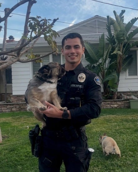 Social media users are swooning over a photo of Officer Parks with the Burbank Police Department, cuddling up with some pups while on duty