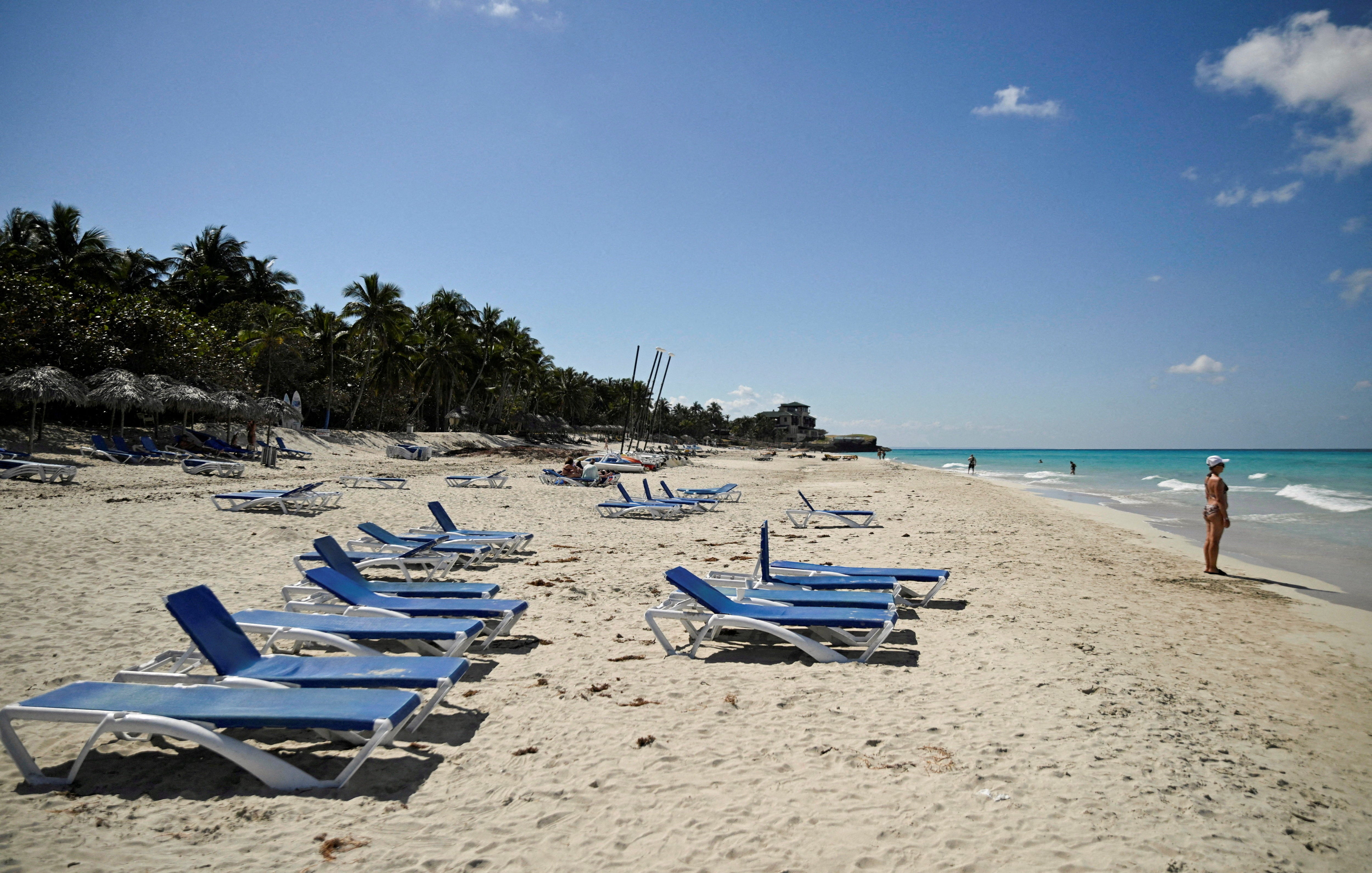 <p>A tourist stands on the beach next to empty sun loungers as the U.S. blocks shipments of oil from reaching the island nation, in Varadero, Cuba</p>