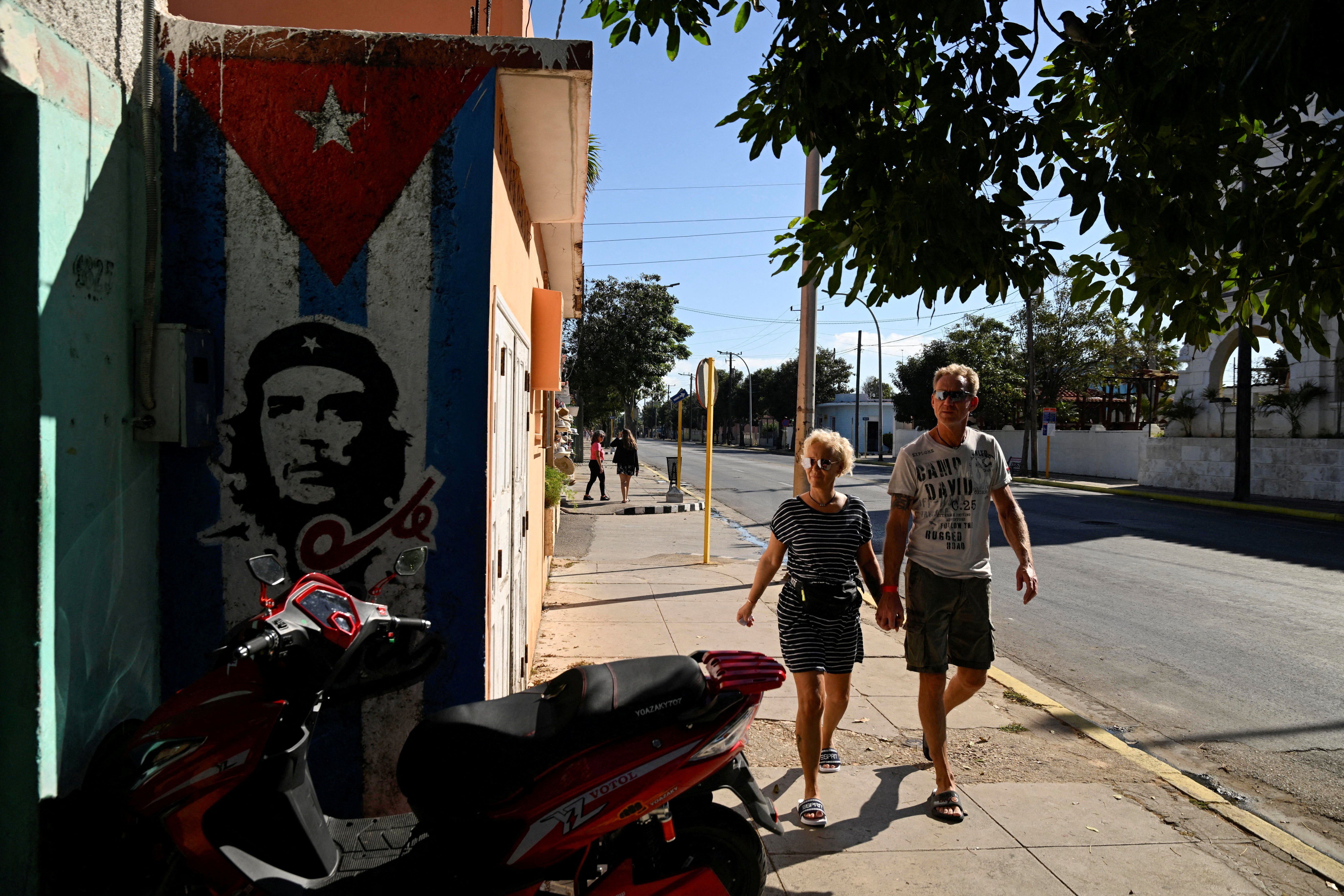 Tourists walk past a mural of late revolutionary hero Che Guevara as the U.S. blocks shipments of oil from reaching the island nation, Varadero, Cuba