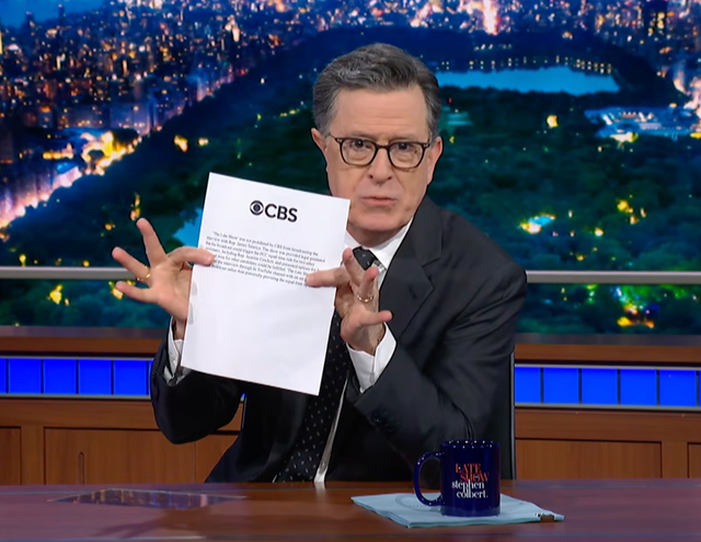 <p>Stephen Colbert holds up a printed copy of CBS's statement on Tuesday's instalment of The Late Show</p>