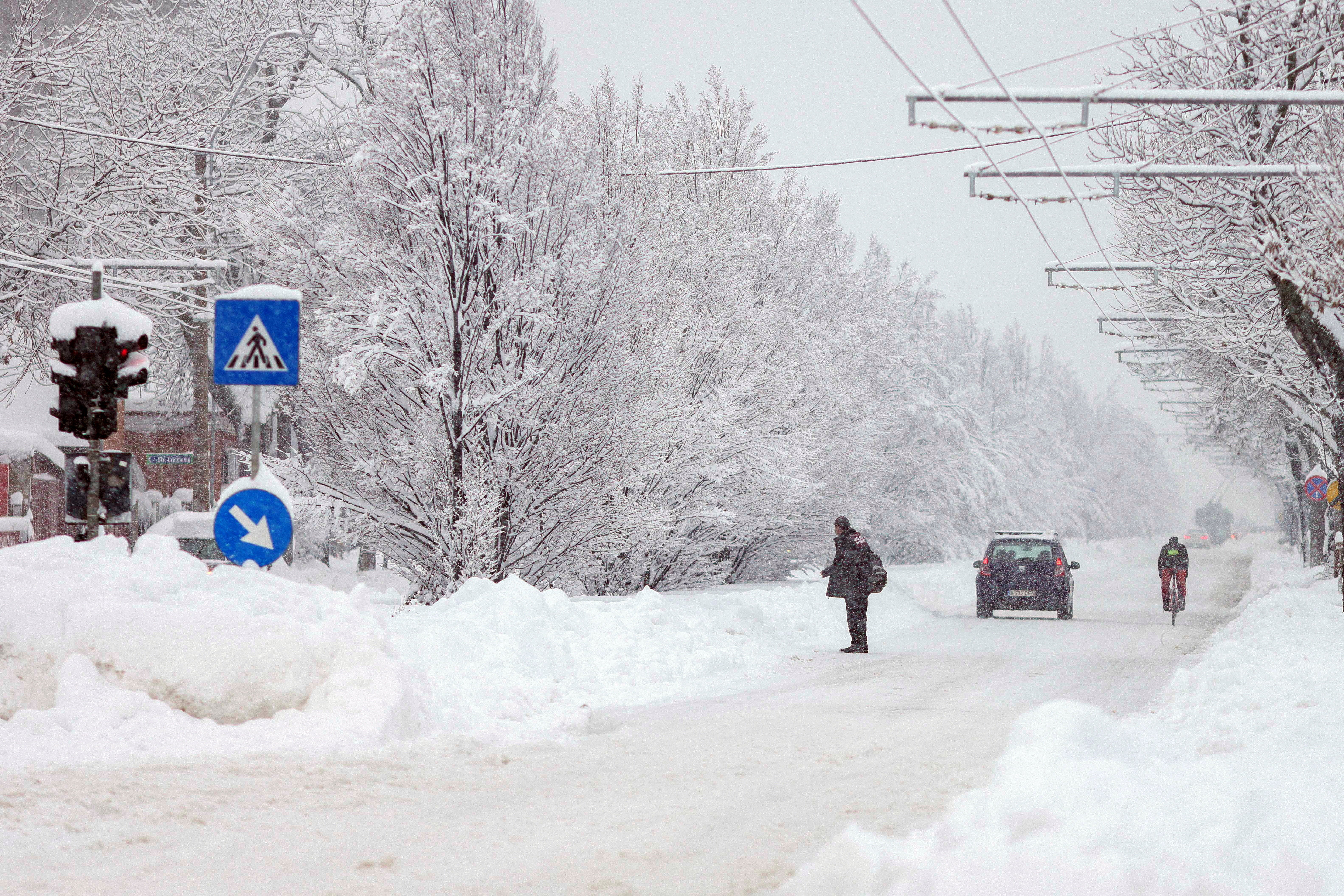 <p>A man stands on a snow-covered road, following a snowstorm in Bucharest, Romania</p>