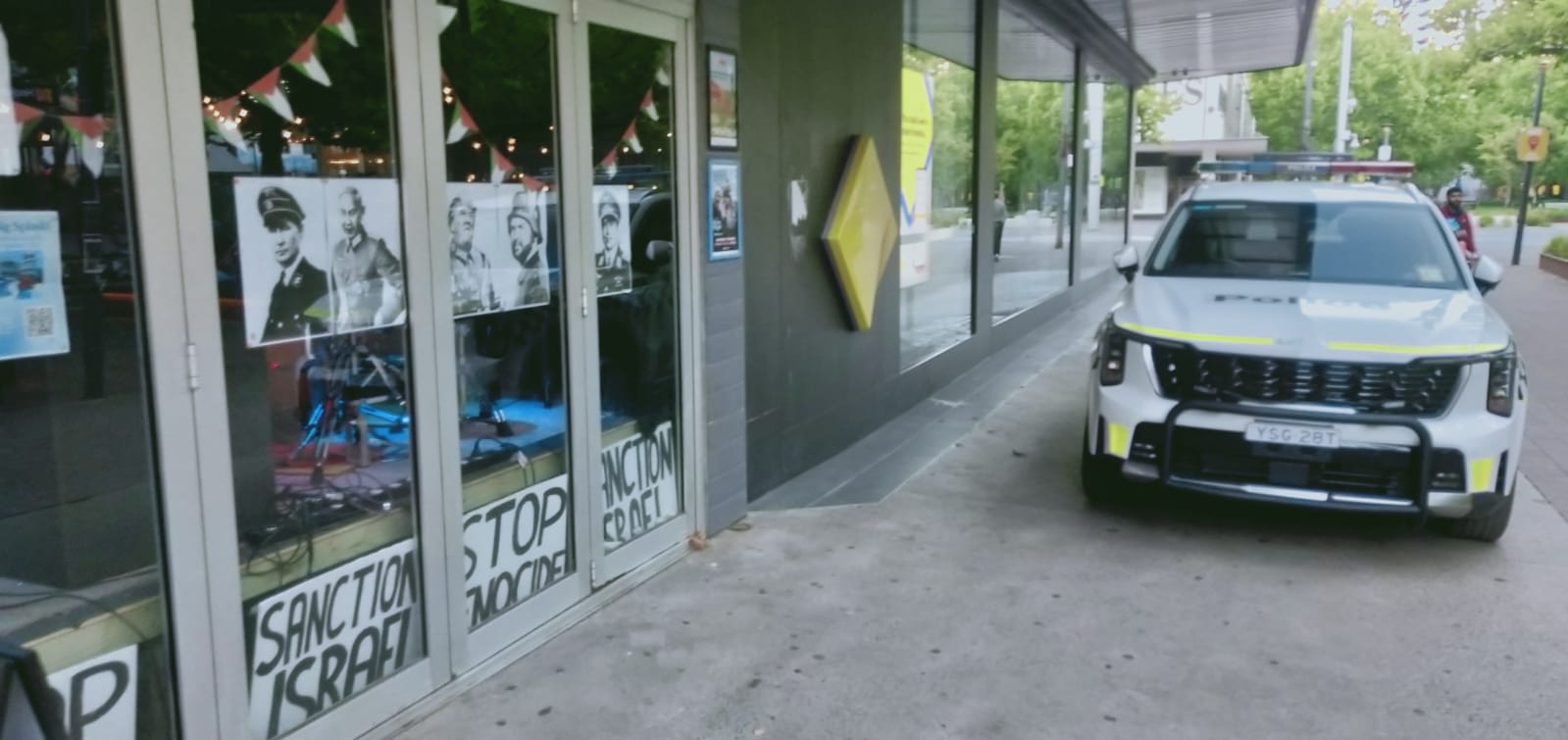 The facade of the venue shows posters of world leaders wearing Nazi uniforms