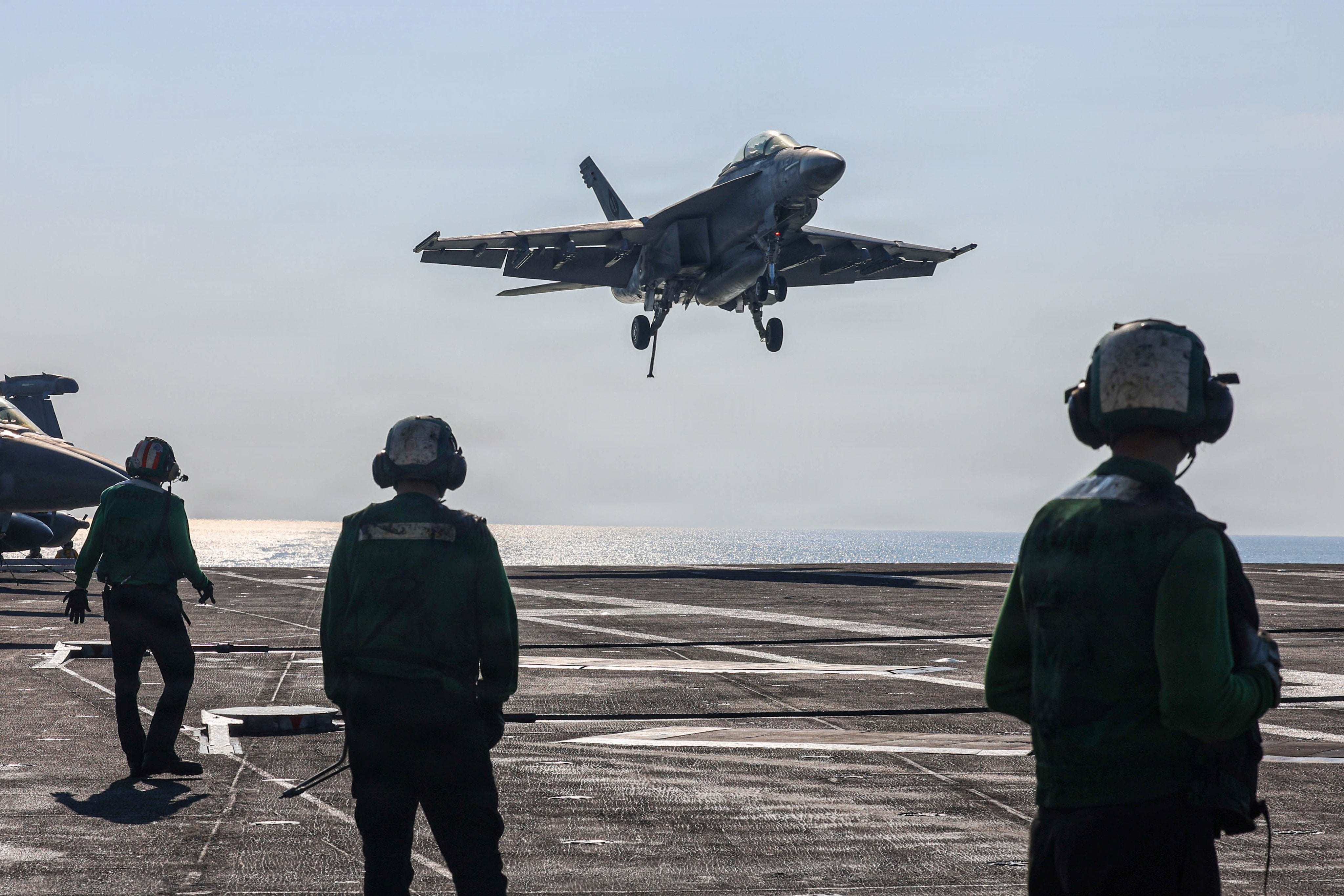 F/A-18 Super Hornets from Strike Fighter Squadron 14 land on the deck of USS Abraham Lincoln (CVN 72) in the Arabian Sea