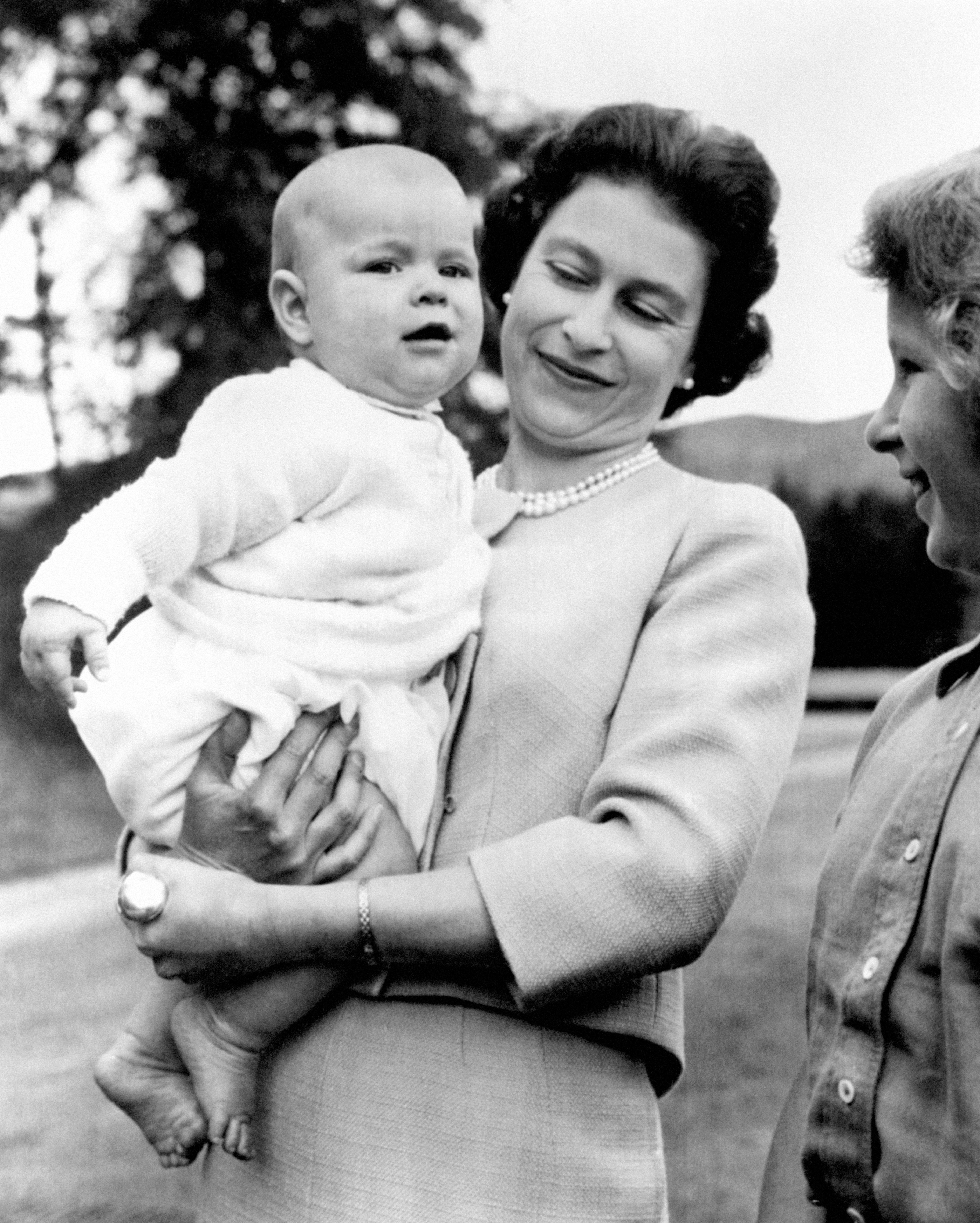 Queen Elizabeth II holding baby Prince Andrew during an outing in the grounds at Balmoral, Scotland, in 1960