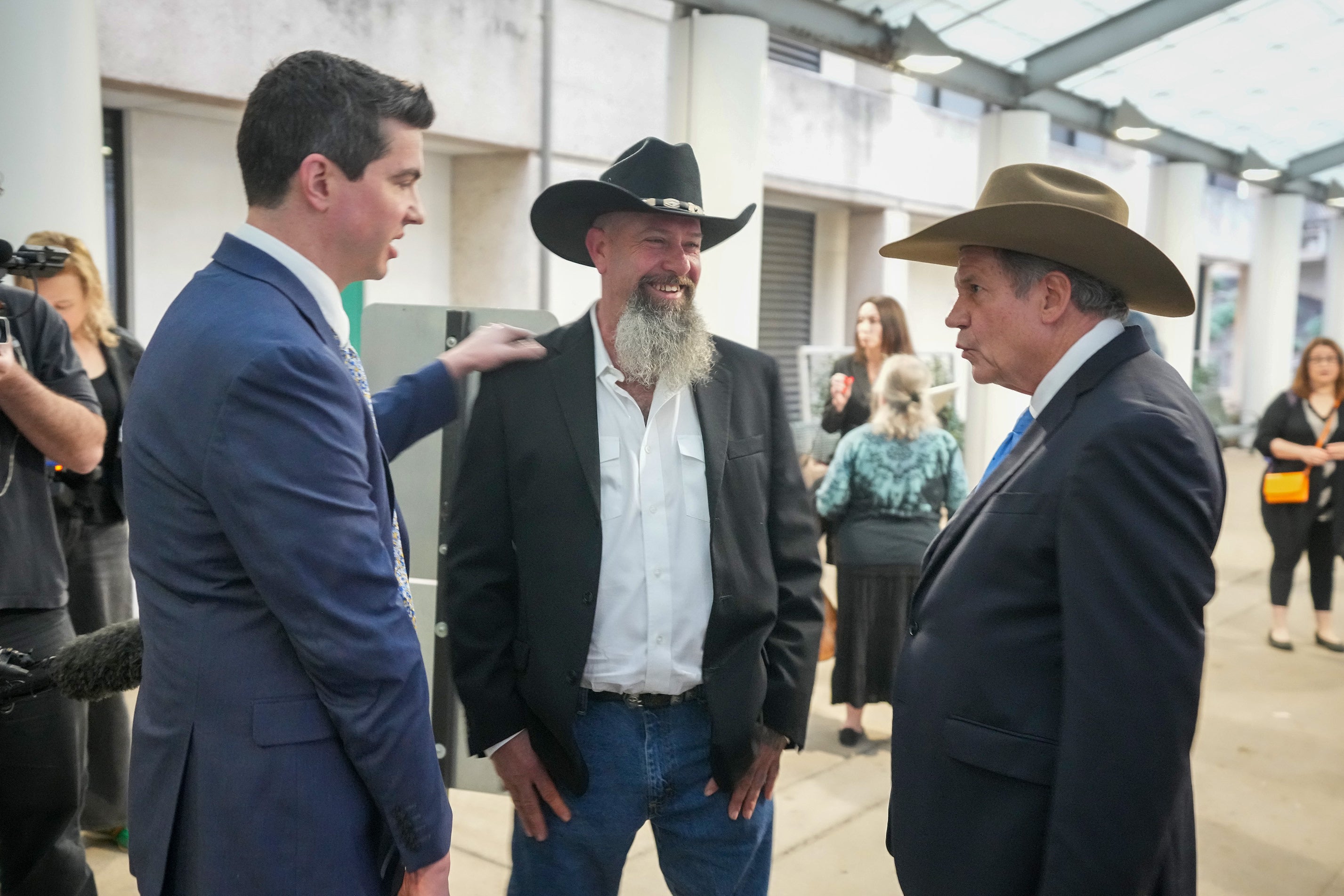 Forrest Welborn, middle, arrives with his attorneys at the exoneration hearing for four men wrongfully accused