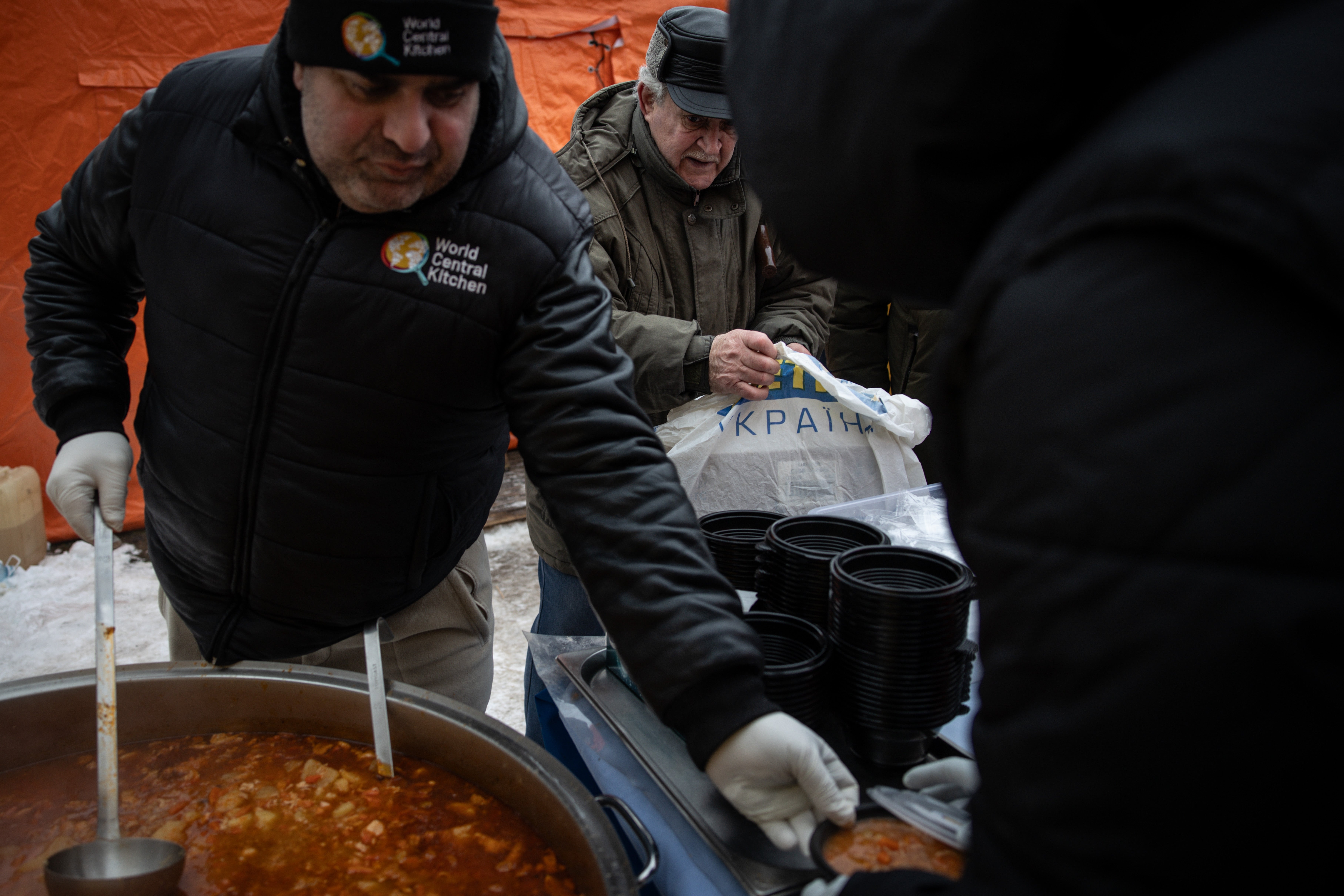 People wait in freezing temperatures to receive food aid distributed by the World Central Kitchen