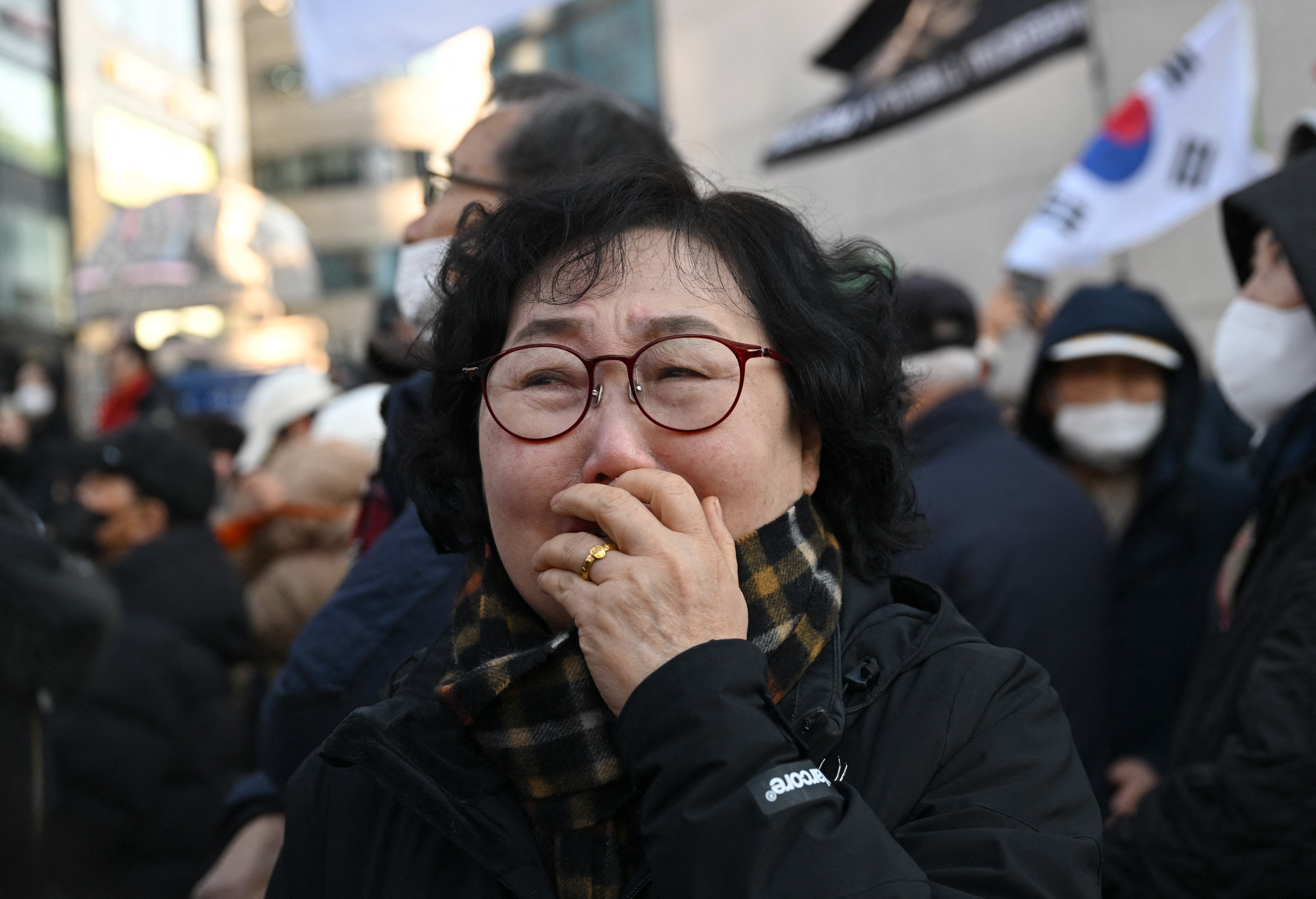 Supporters of South Korea's impeached former president Yoon Suk Yeol react as they watch a live stream of Yoon's trial on his insurrection charges near the Seoul Central District Court in Seoul
