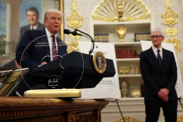 <p>President Donald Trump speaks behind an engraved glass disc gifted to him by Apple CEO Tim Cook during an event in the Oval Office of the White House last year </p>