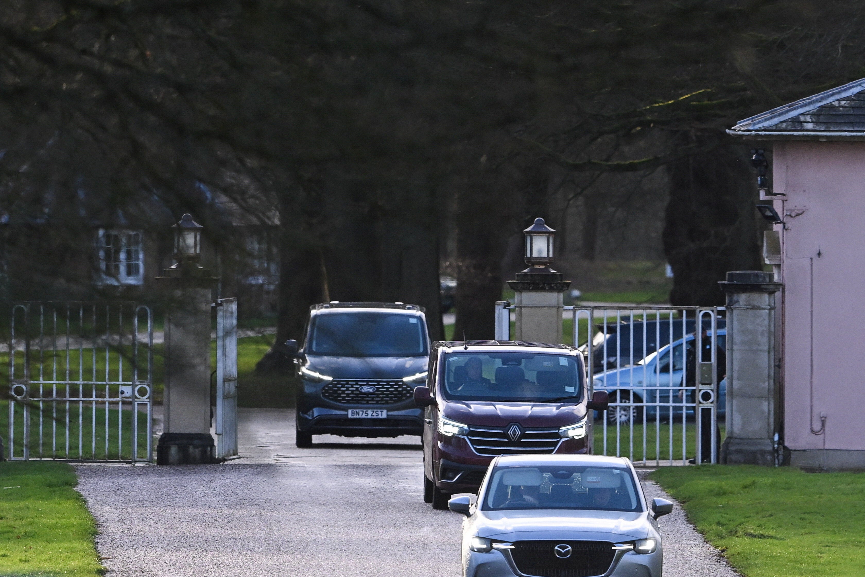 Police in vehicles drive by an entrance to the Royal Lodge, a property on the estate surrounding Windsor Castle and a former residence of Andrew Mountbatten-Windsor