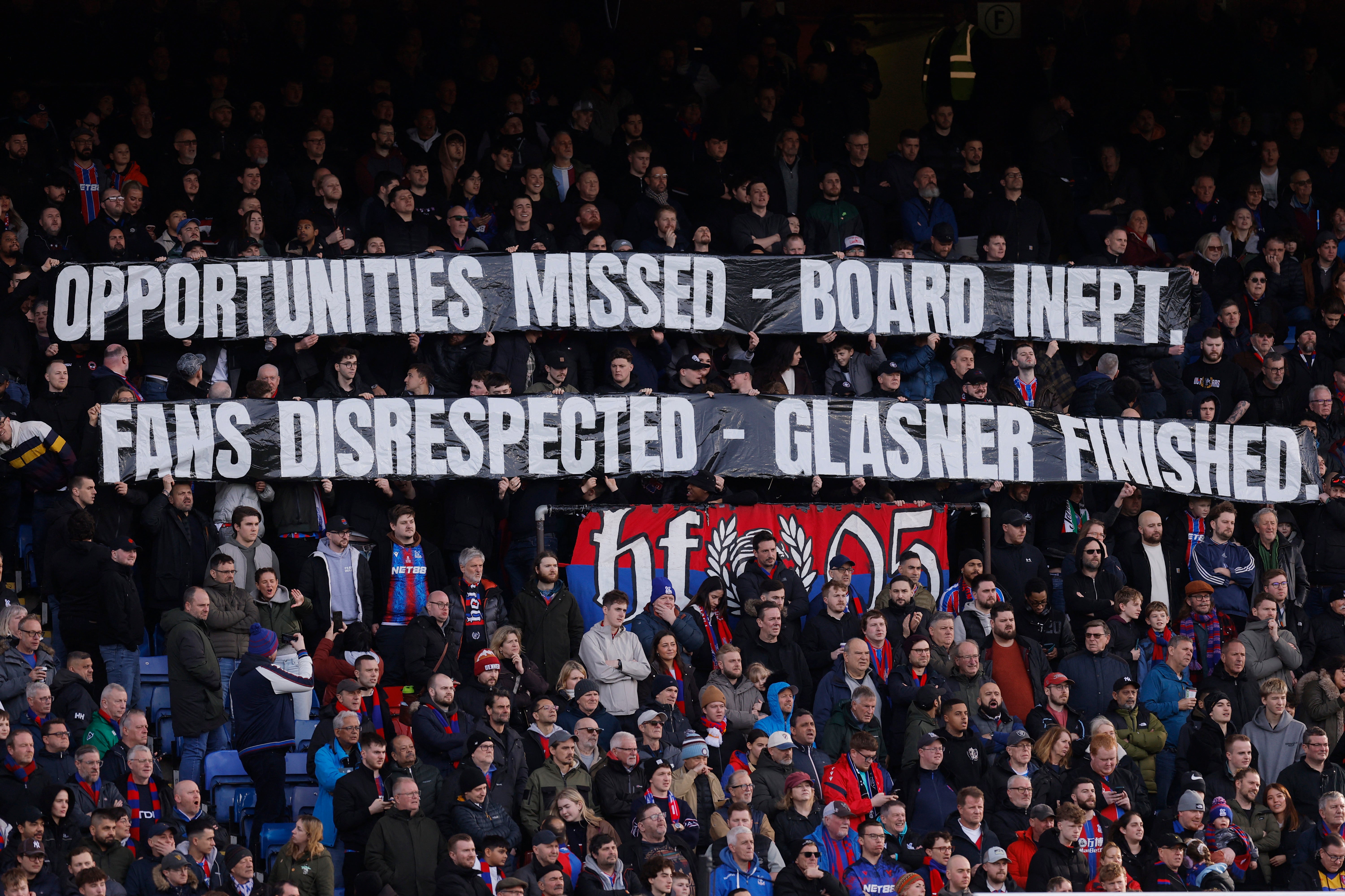 <p>Crystal Palace fans with a banner in protest to ownership and manager Oliver Glasner </p>
