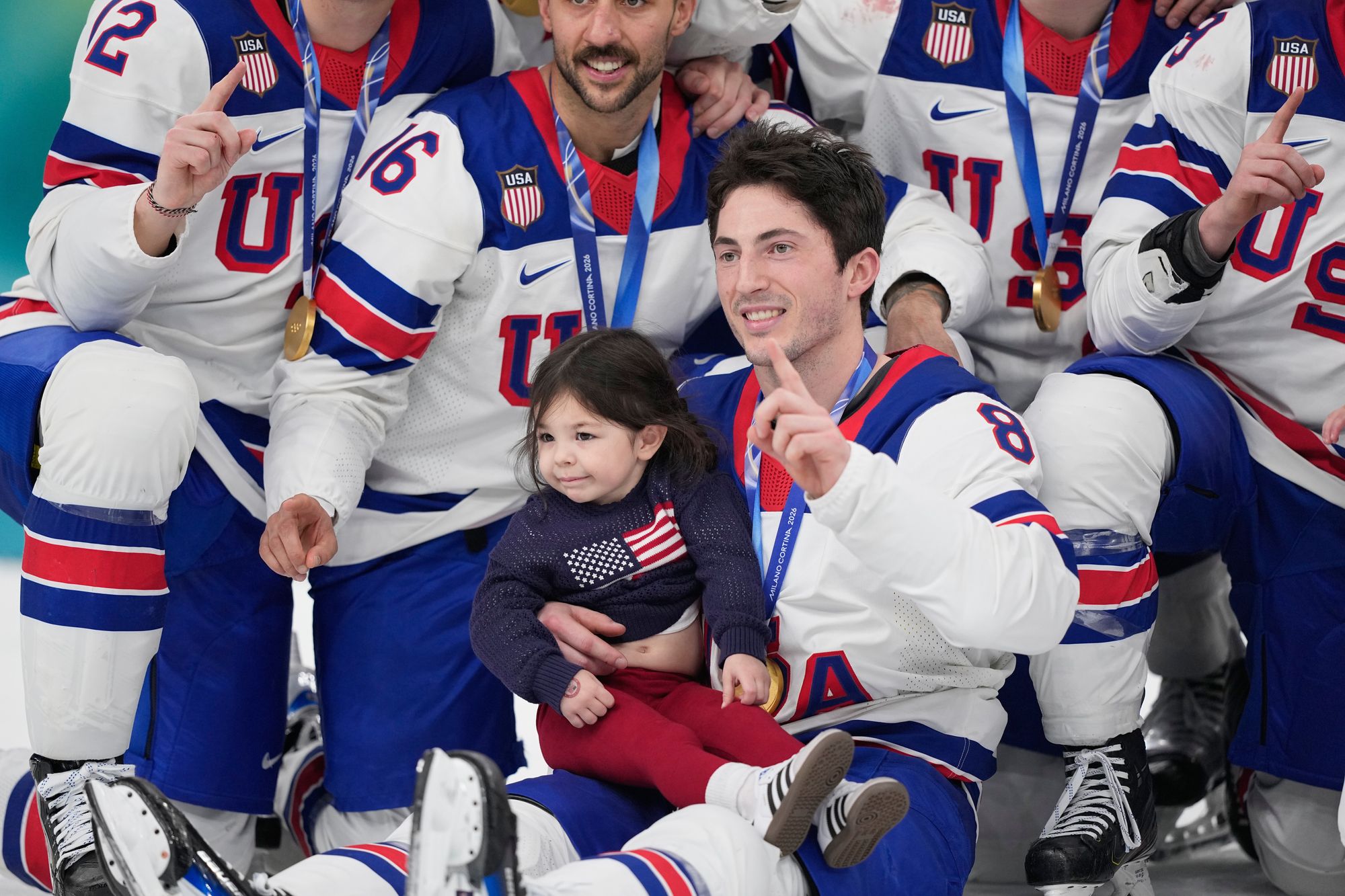 United States' Zach Werenski poses with Noa, the daughter of late player Johnny Gaudreau