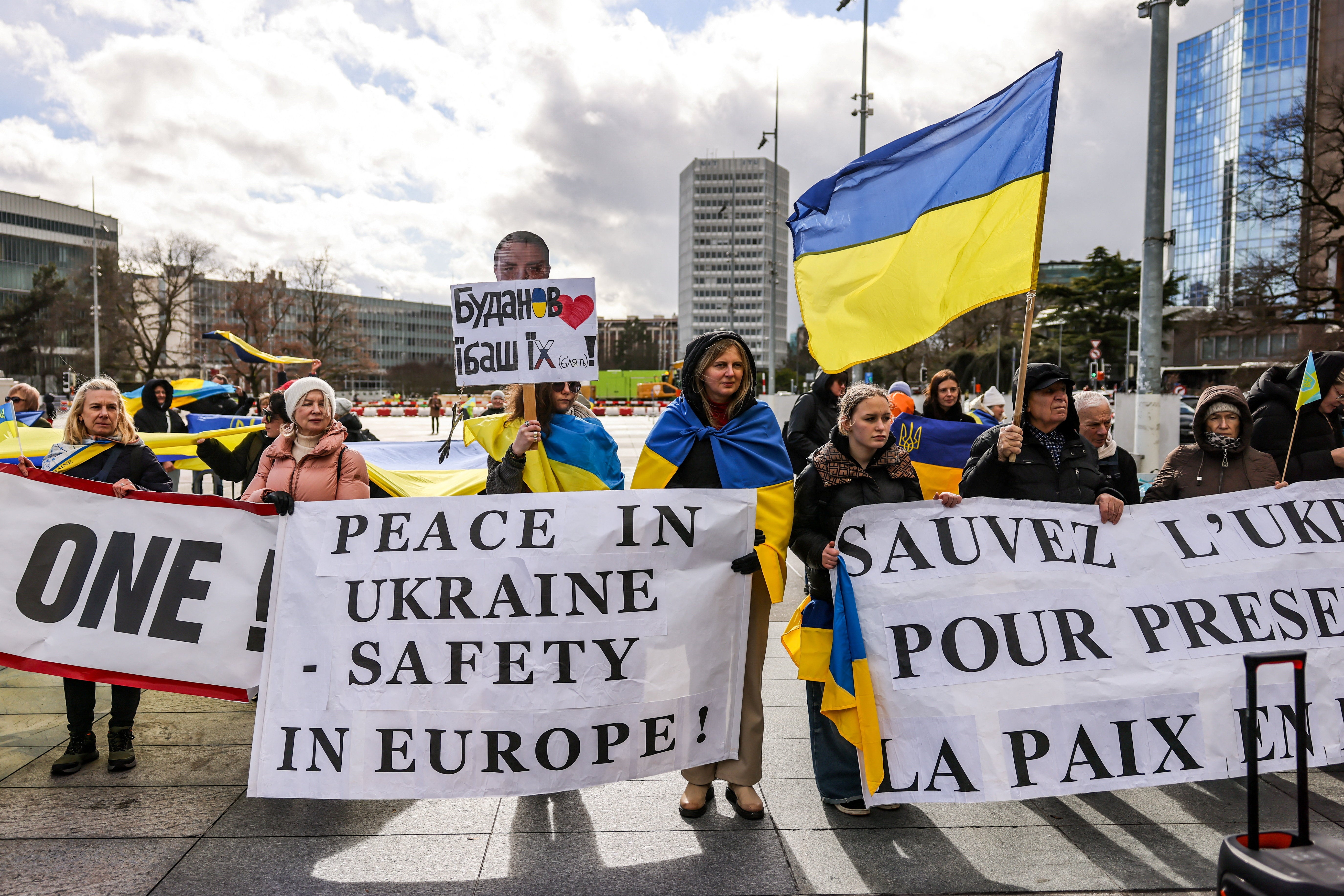 People carry banners at a protest near the United Nations office, on the day of U.S.-mediated peace talks between Russia and Ukraine in Geneva, Switzerland