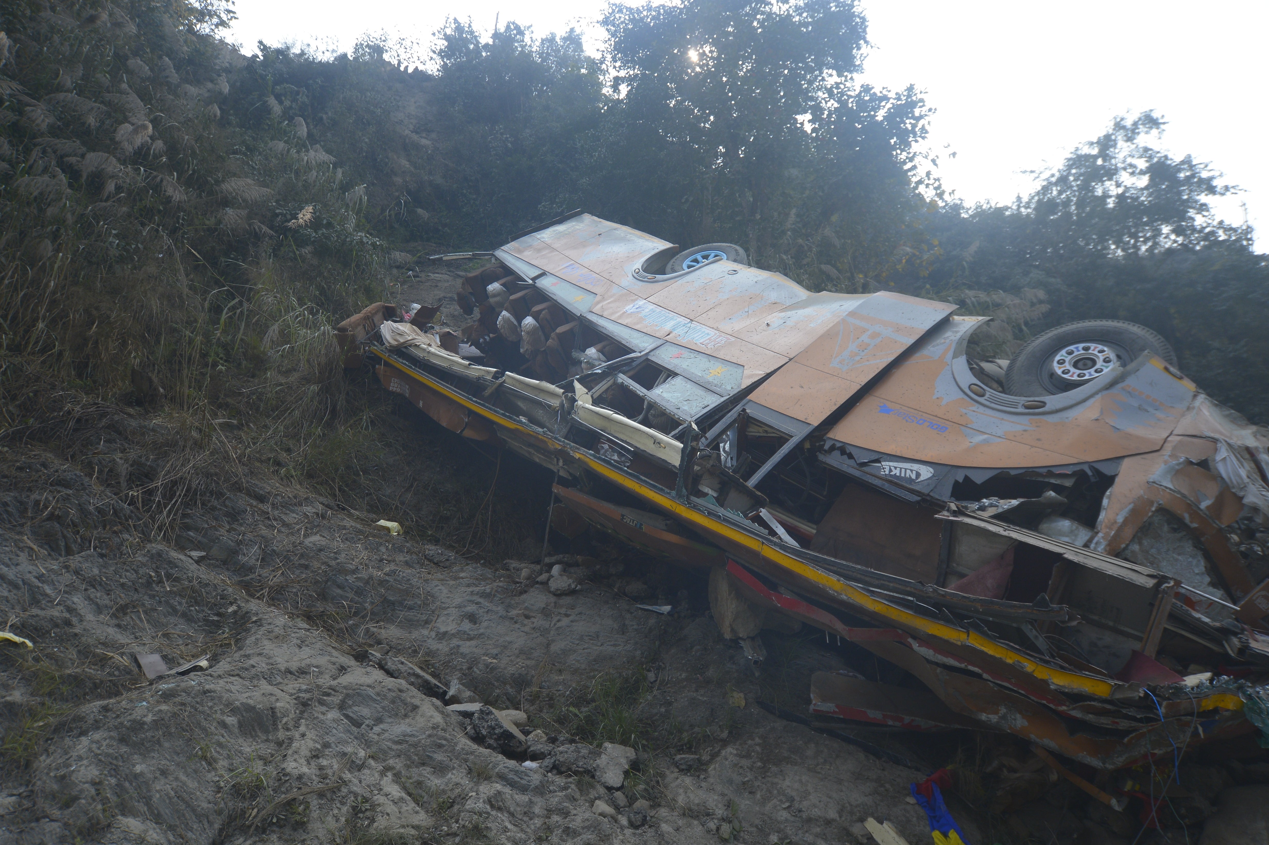 <p>The wreckage of a bus is seen on the bank of the Trishuli River after it drove off a mountain highway near Benighat, west of the capital, Kathmandu, Nepal</p>