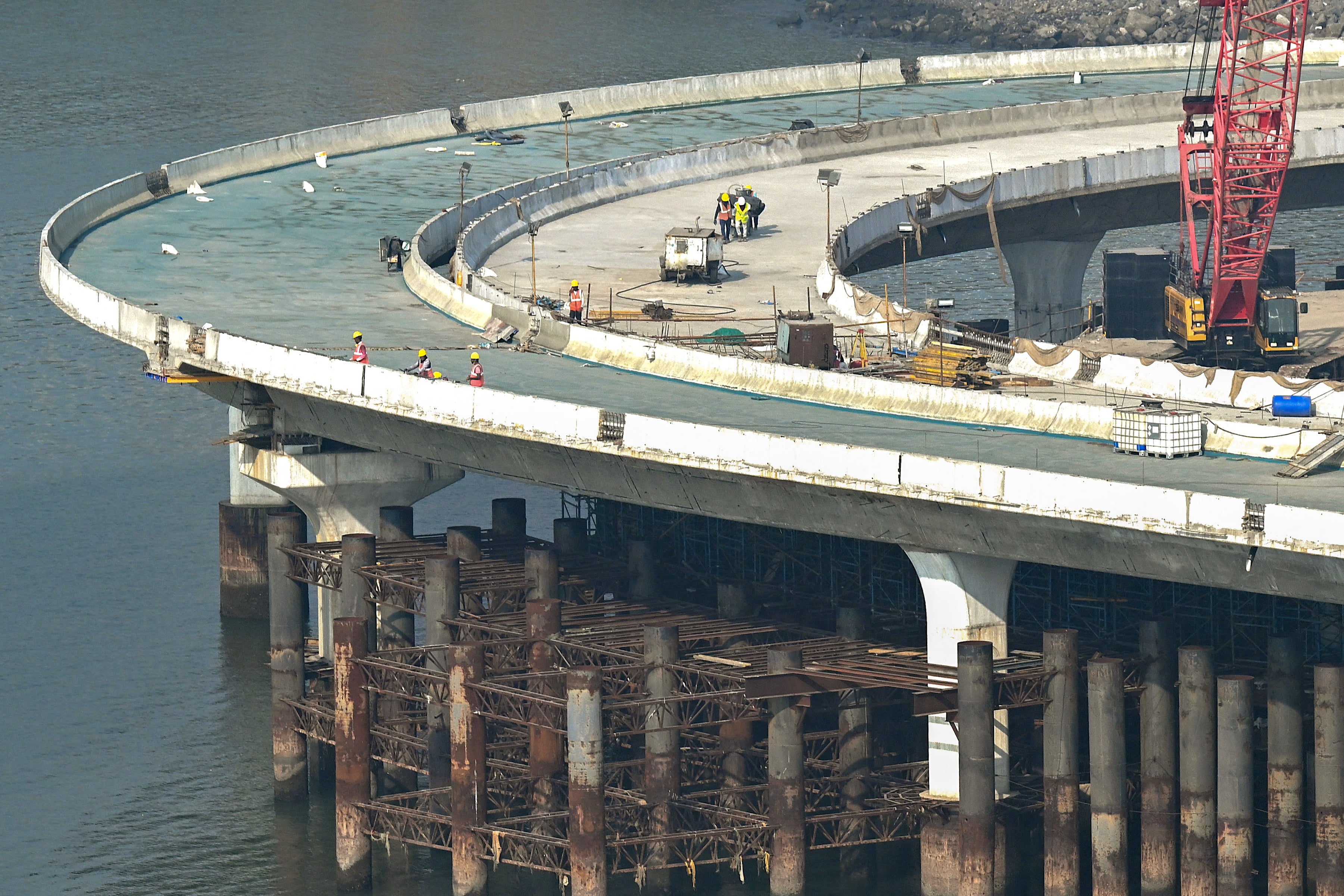 Labourers work on a section of the Coastal Road expressway along the Arabian Sea coast in Mumbai
