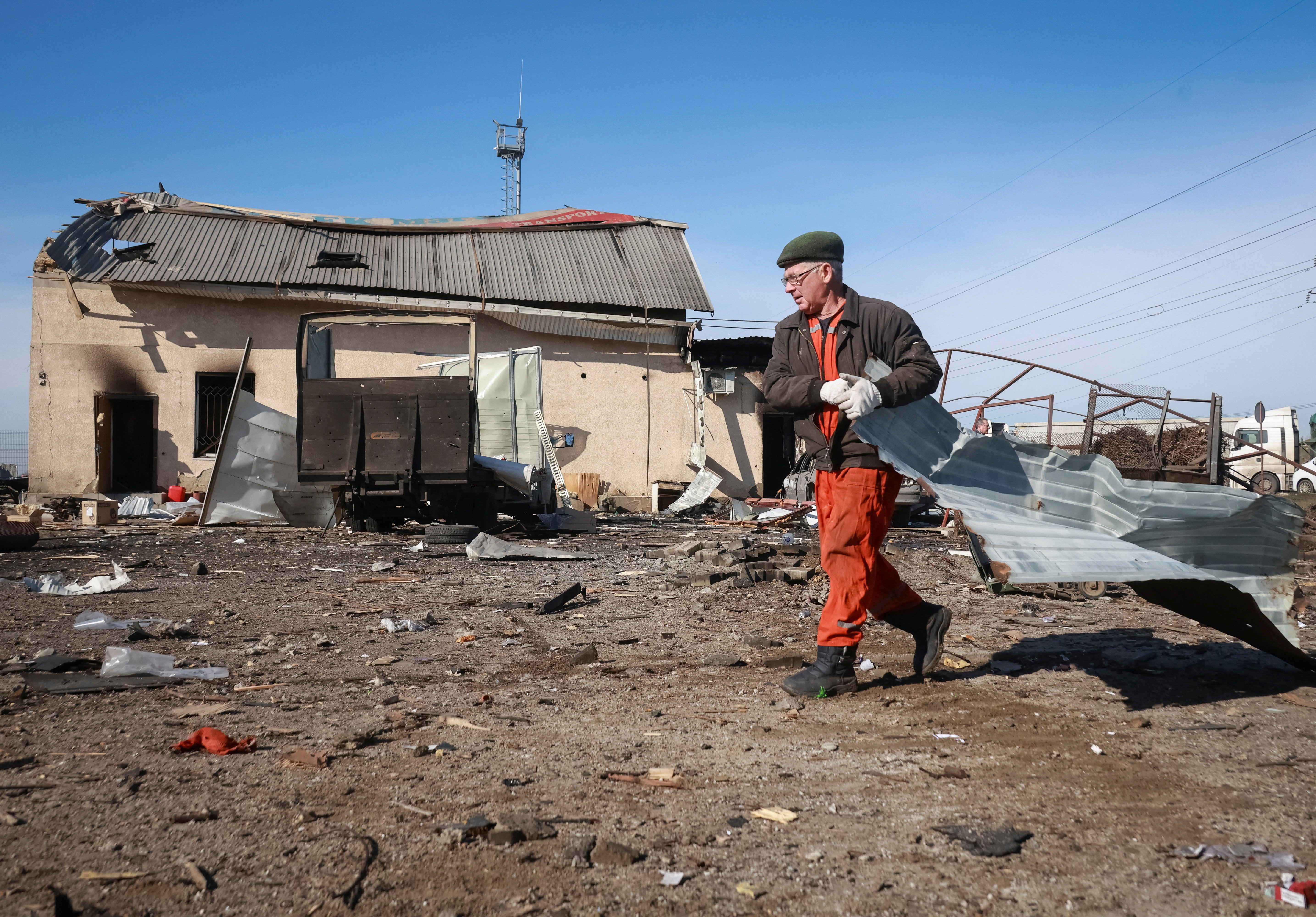 A resident cleans an area at the site of the Russian drone strike, amid Russia's attack on Ukraine, near the city of Chornomorsk, Odesa region, Ukraine February 23, 2026