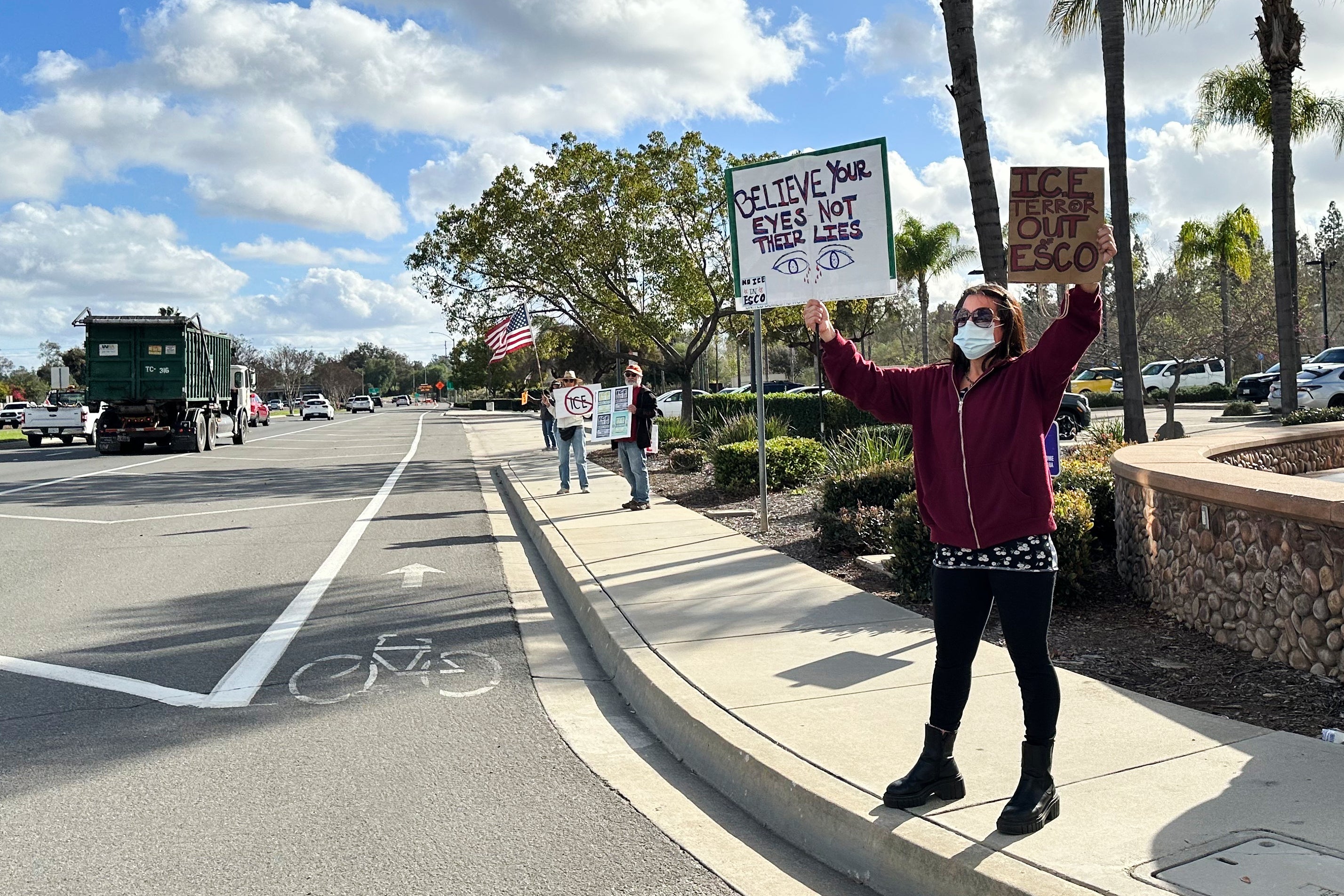 Demonstrators hold signs outside a police station