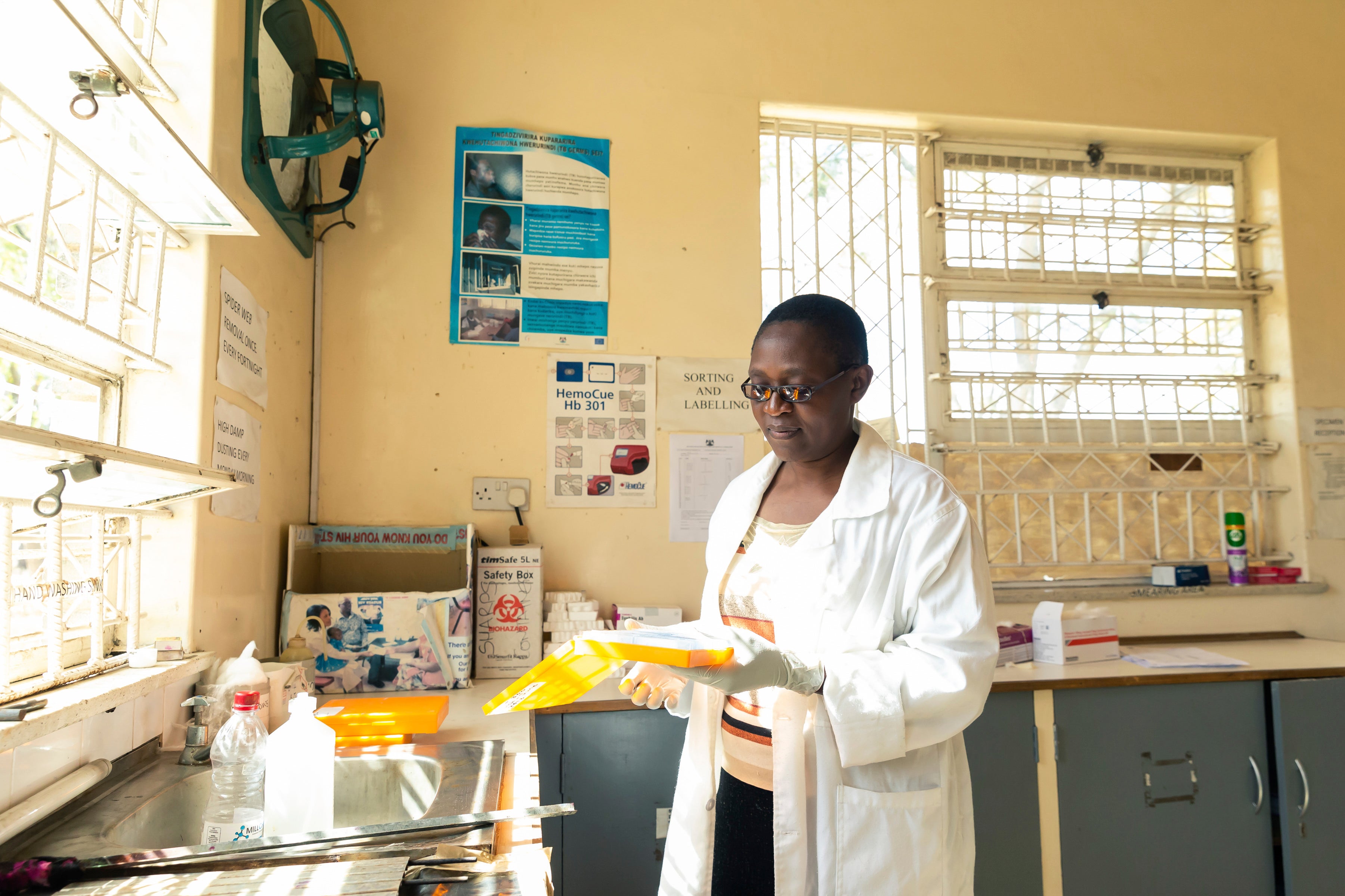 Microscopist Mazvita Chataurwa prepares slides to conduct tests on in an on-site laboratory, at Rutsanana Polyclinic in Glen Norah township, Harare