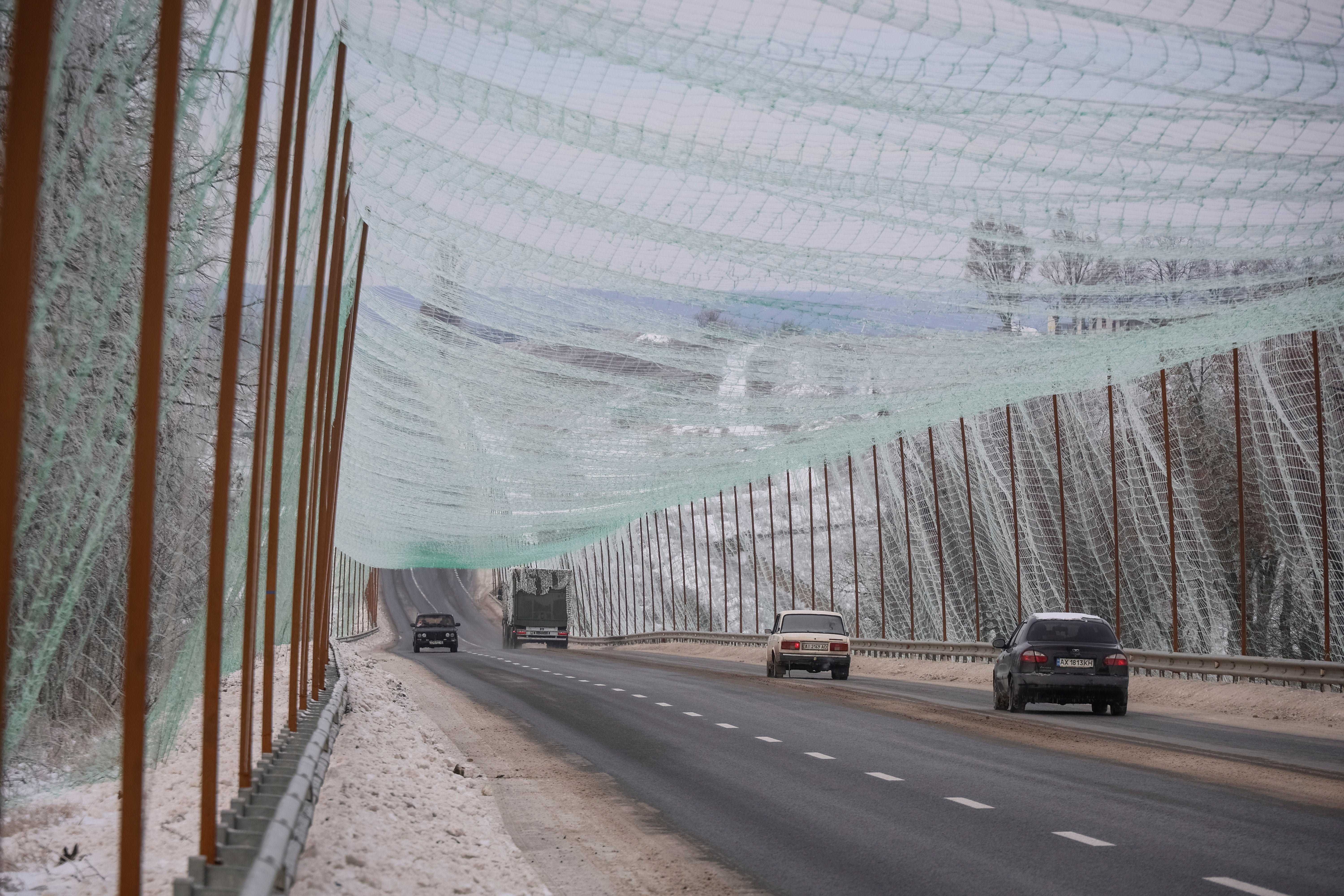 Cars drive along a road covered with an newly installed anti-drone net (REUTERS/Vyacheslav Madiyevskyy)