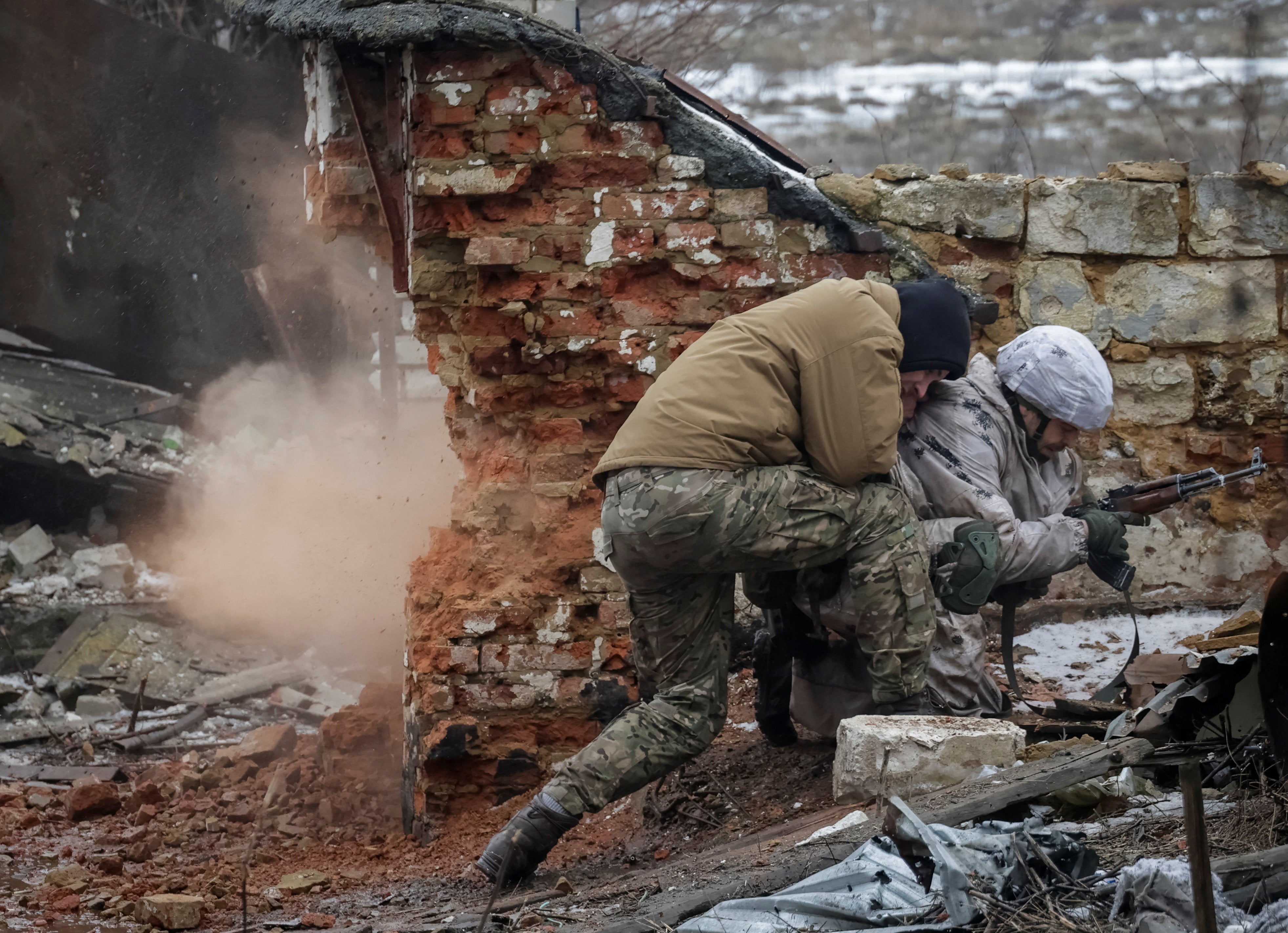 An Instructor pushes a recruit of the 28th Separate Mechanized Brigade of the Armed Forces of Ukraine during a grenade explosion during a military exercise before combat missions