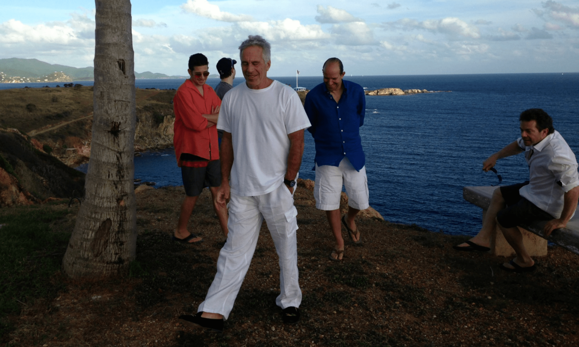The photo appears to show Lutnick, Epstein and three other individuals on a cliffside overlooking the ocean