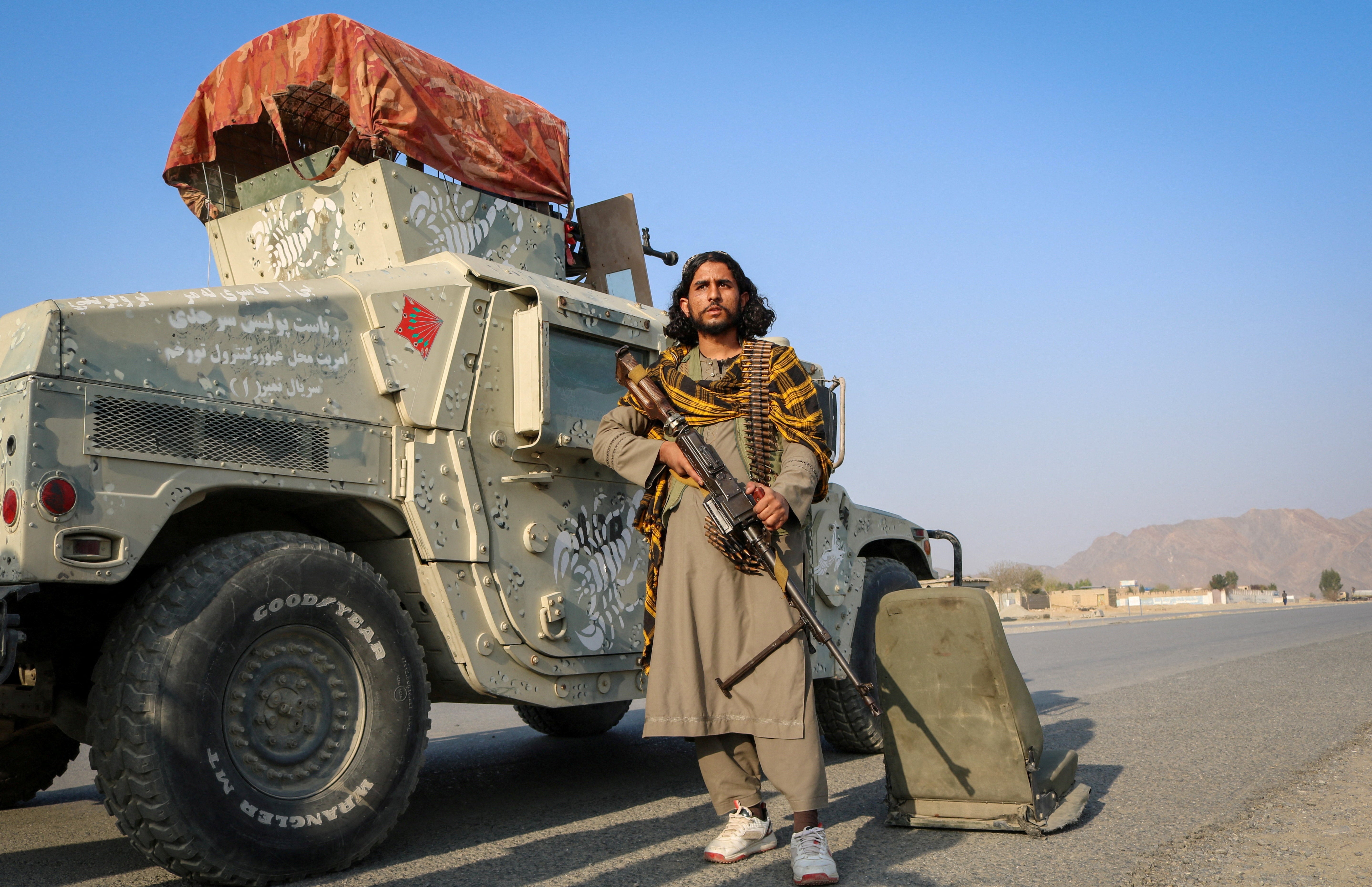 A Taliban soldier holds his gun as he stands next to a Humvee, following exchanges of fire between Pakistan and Afghanistan forces, in Momand Dara, in Nangarhar