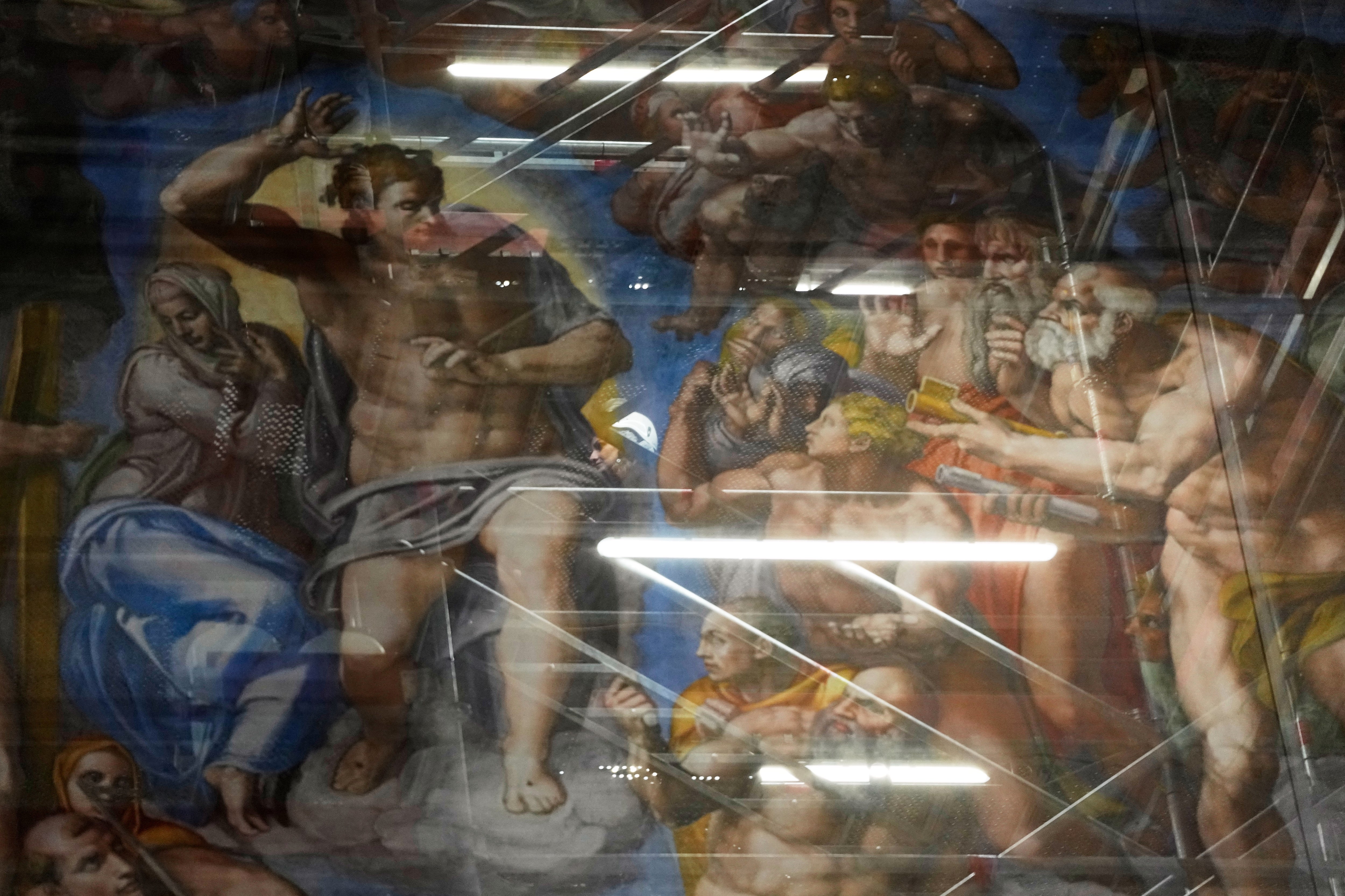 <p>A woman walks behind a screen with a replica of ‘The Last Judgment,’ superimposed on it that covers the scaffolding used for its extraordinary maintenance during a presentation for press in the Sistine Chapel at the Vatican, Saturday, Feb. 28, 2026. (AP Photo/Alessandra Tarantino)</p>