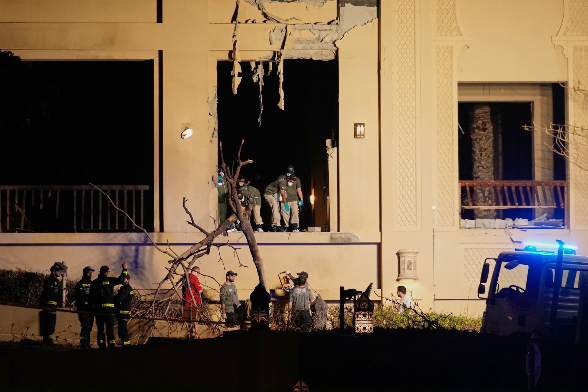 Firemen and rescue workers inspect the site of an explosion at the Fairmont The Palm Hotel in Dubai