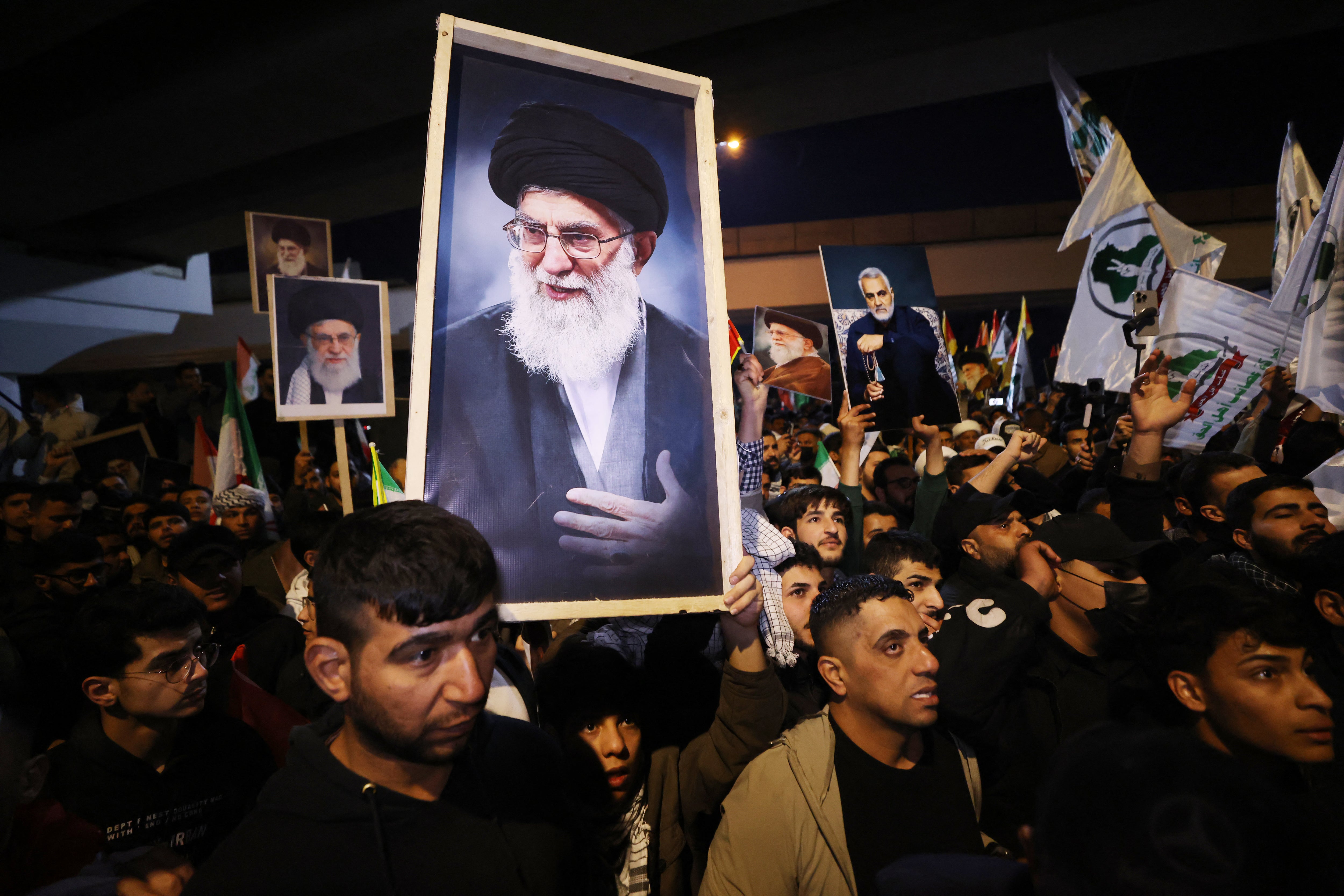 Iraqi Shiites carry a portrait of Iran's Supreme Leader Ayatollah Ali Khamenei during a protest against US and Israeli attacks on Iran at a bridge leading to Green Zone where the US embassy is located, in Baghdad on February 28, 2026