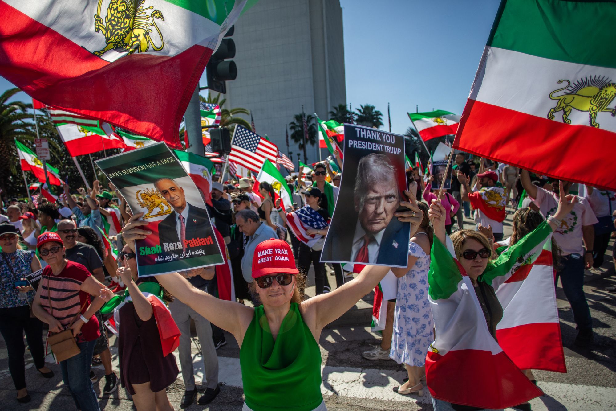 A woman holds pictures of Reza Pahlavi and US President Donald Trump as members of the Iranian community celebrate in front of the Federal Building in the West LA neighborhood of Los Angeles, on February 28, 2026.