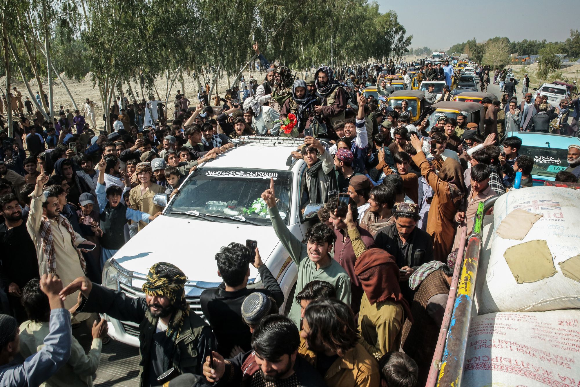 Afghan supporters cheer as they surround a vehicle of Taliban security personnel amid the ongoing clashes between Pakistan and Afghanistan, on the outskirts of Jalalabad on 28 February 2026