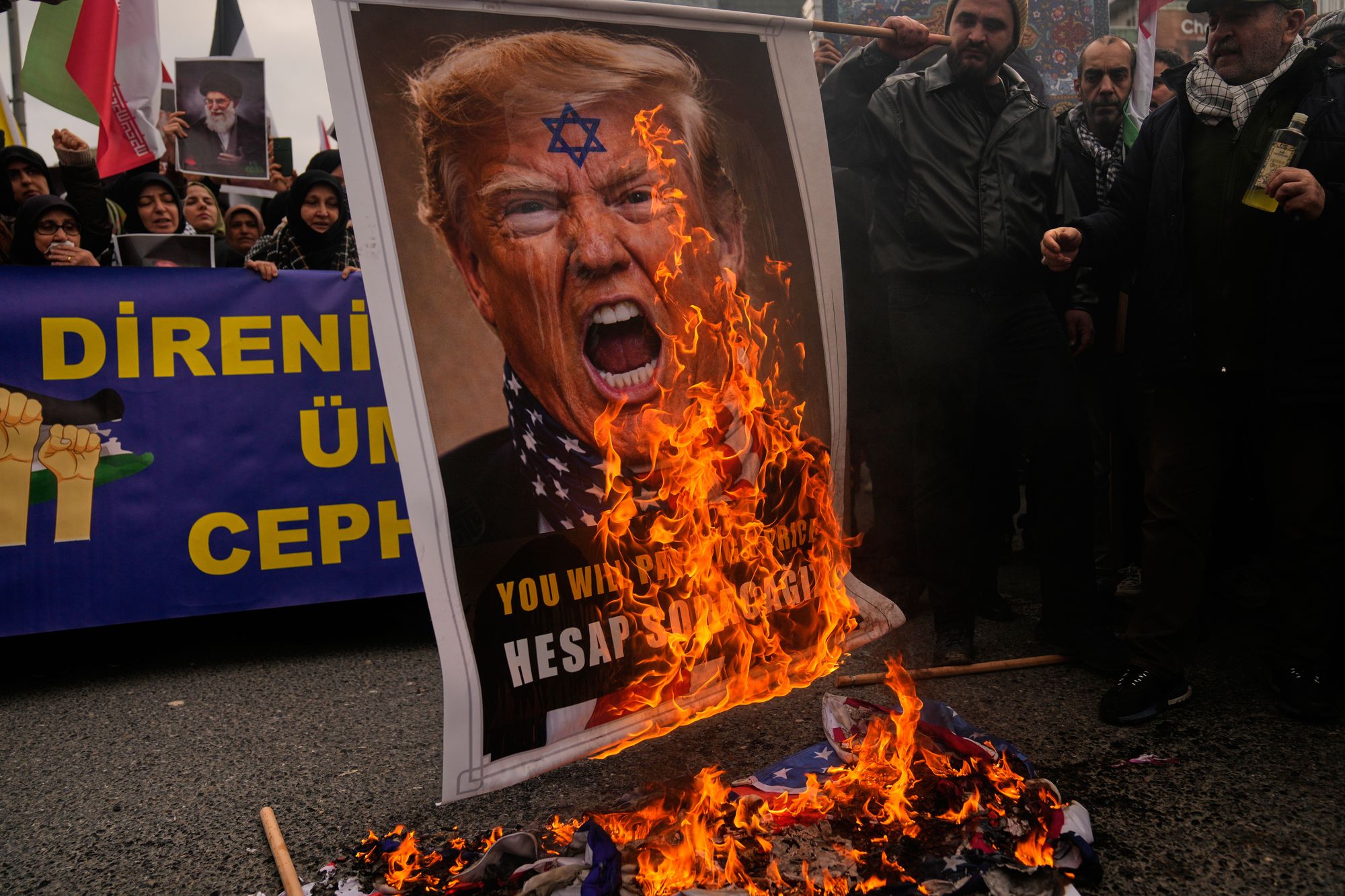 Demonstrators burn a picture of Trump during a protest outside the Israeli consulate in Istanbul, Turkey