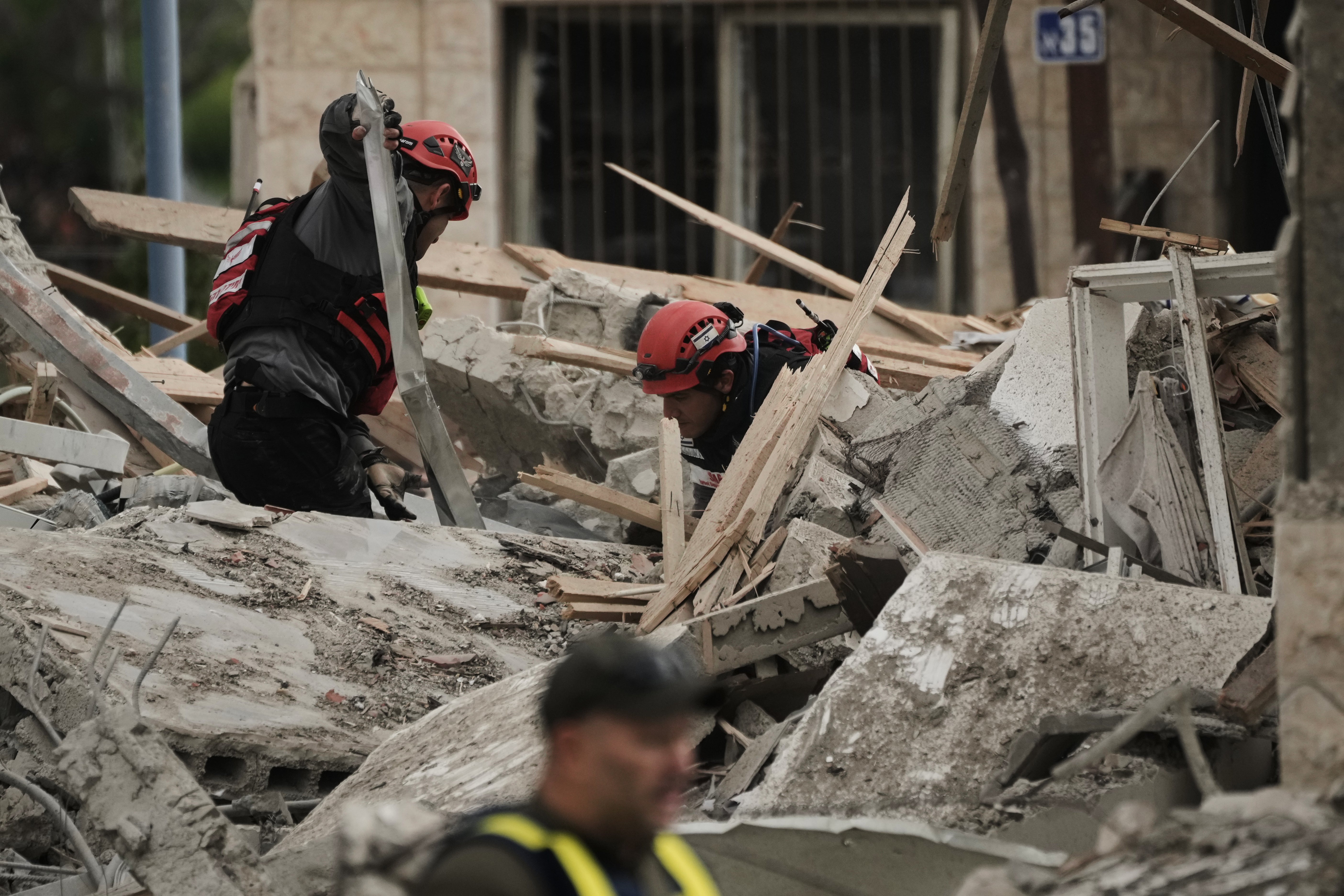 Rescue workers and military personnel operate at the scene where several people were killed in an Iranian missile strike in Beit Shemesh, Israel