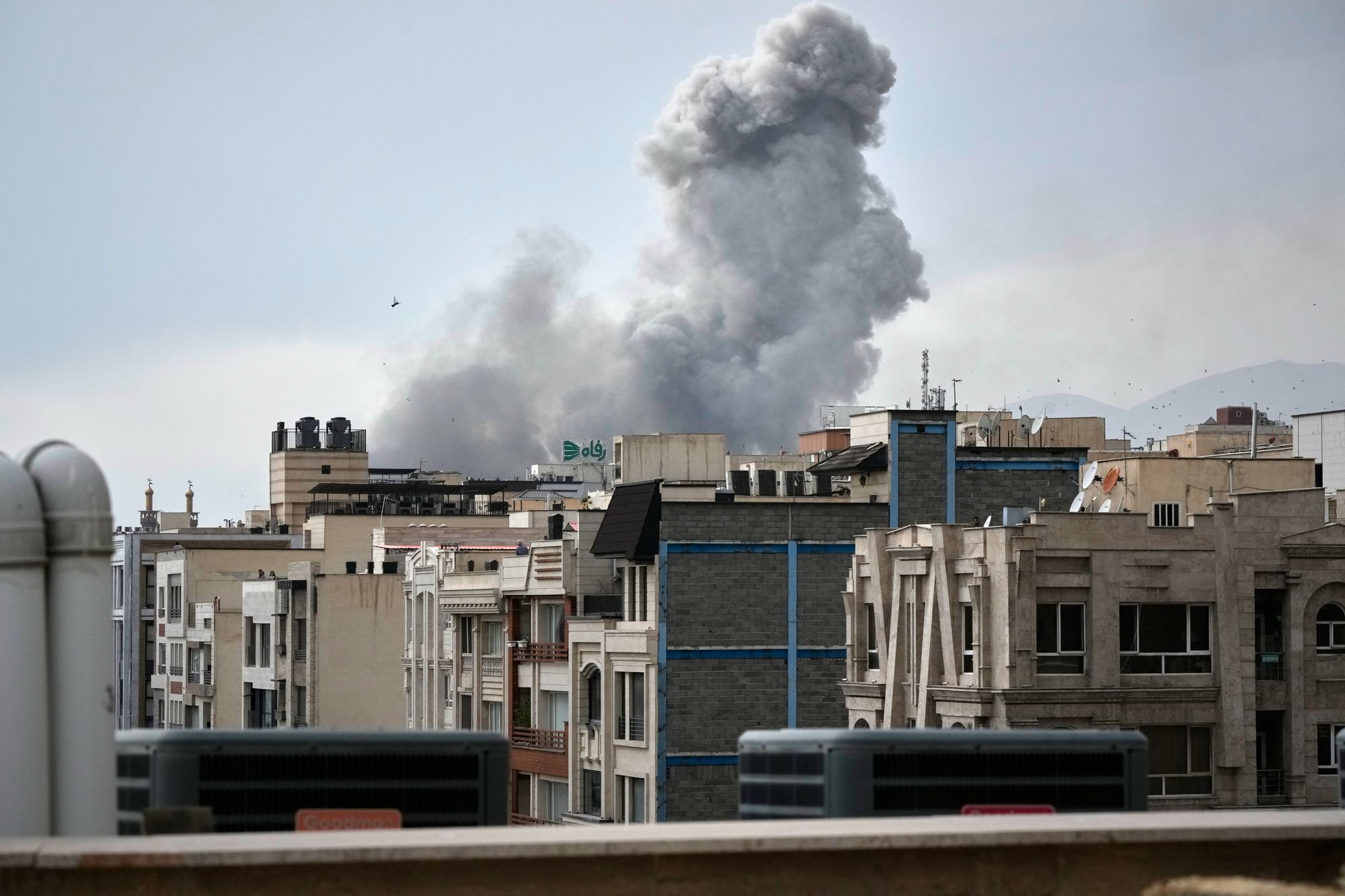 A plume of smoke rises after a strike in Tehran on Monday