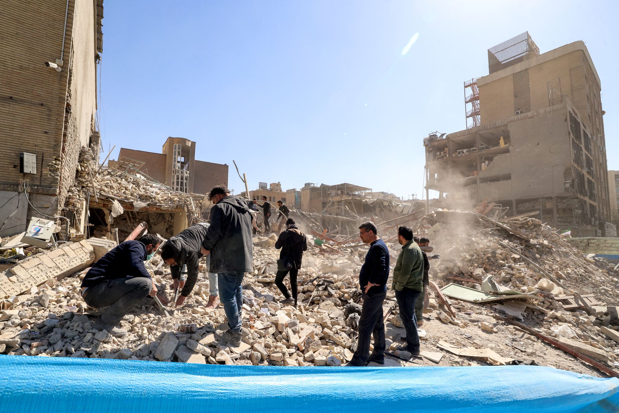 People inspect the rubble of a collapsed building near Ferdowsi square in Tehran on March 3, 2026