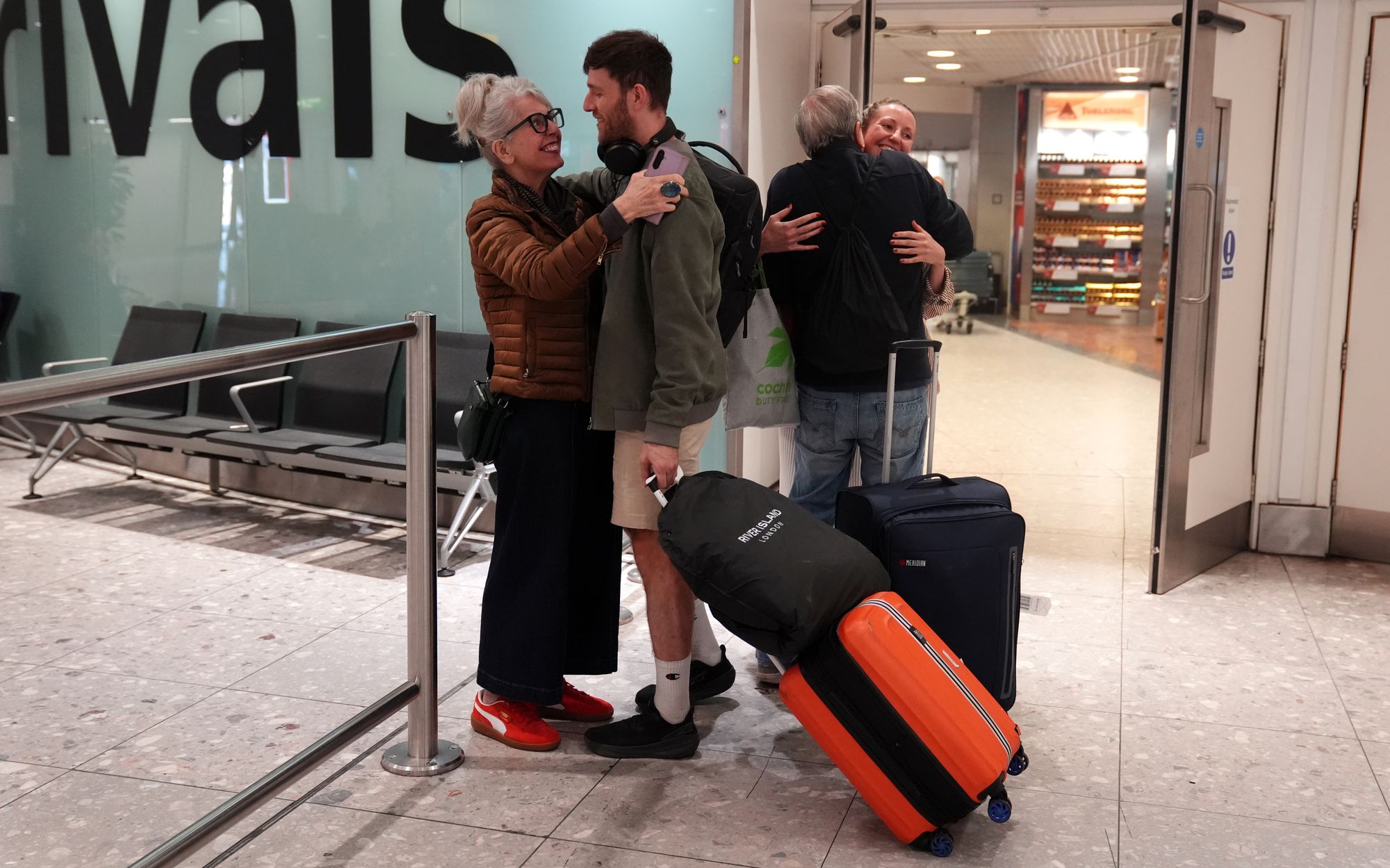 Sue (left) and Terry Luminati (second from right), from Teddington, greet their daughter Nina (right) and boyfriend Lee Smart (second from left), from Thornton Heath, as they arrive at London Heathrow Airport Terminal 3 on a flight from Dubai