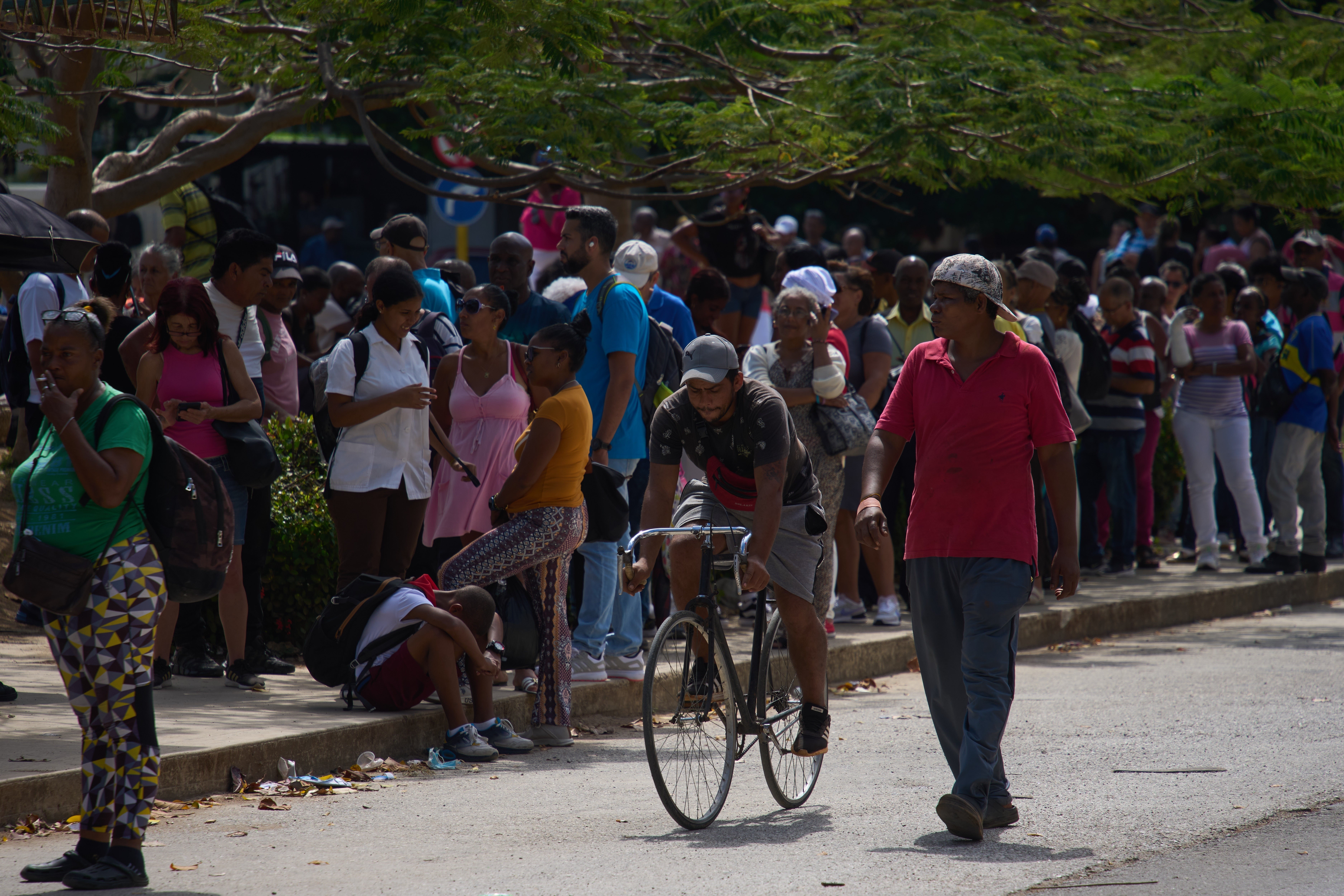 People wait to take public transportation during a blackout in Havana