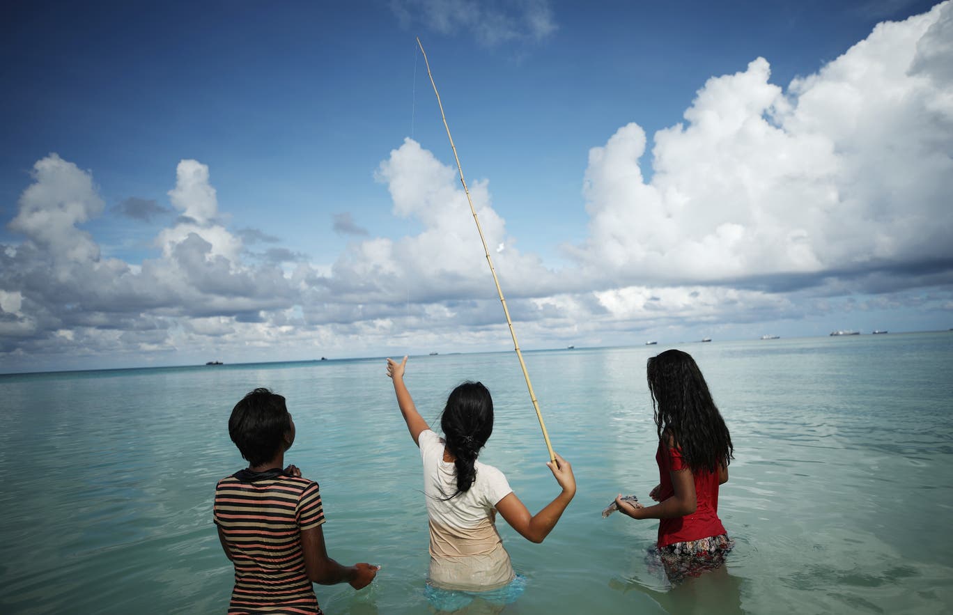 Kids fish in the lagoon on November 28, 2019 in Funafuti, Tuvalu.